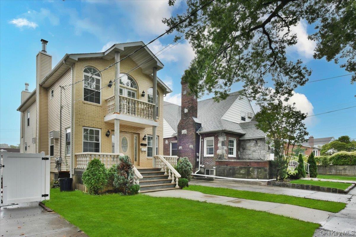 View of front of house with a balcony and a chimney