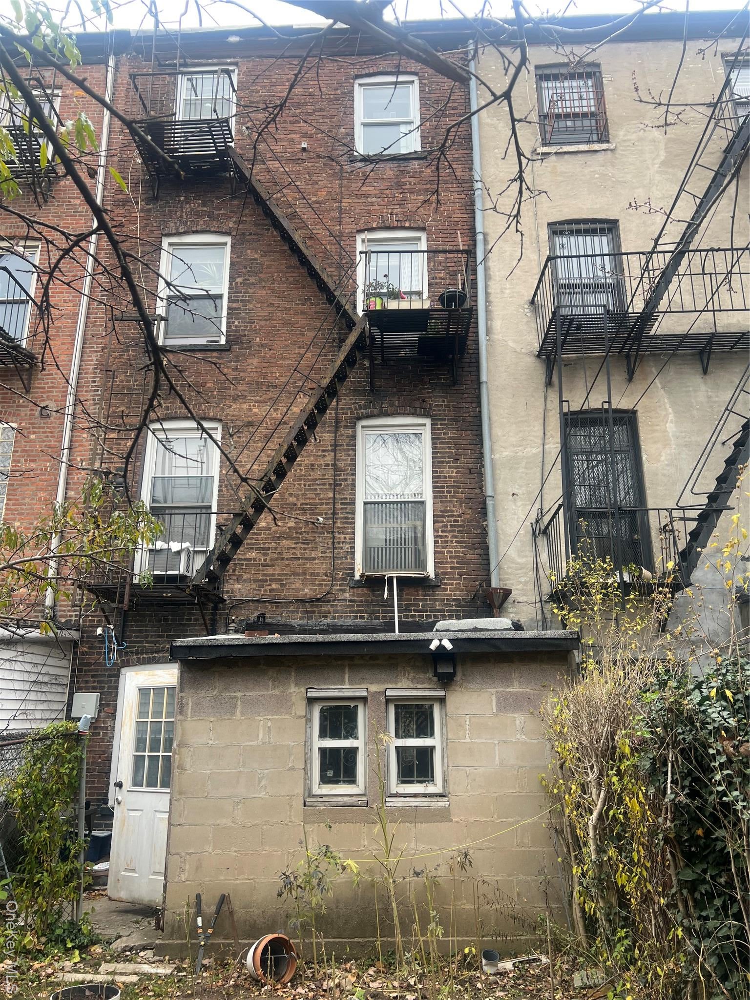 Back of house with brick siding and a balcony