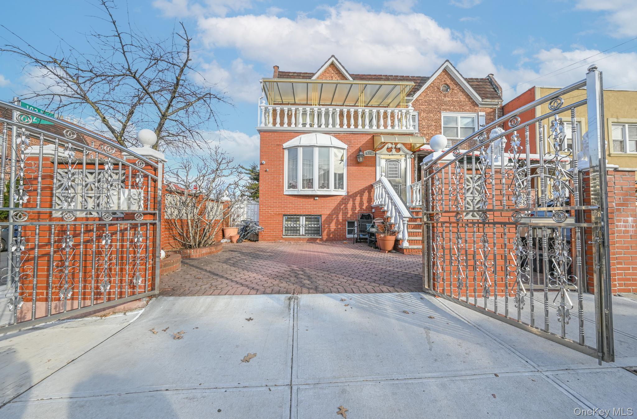 View of front of property with brick siding and a balcony