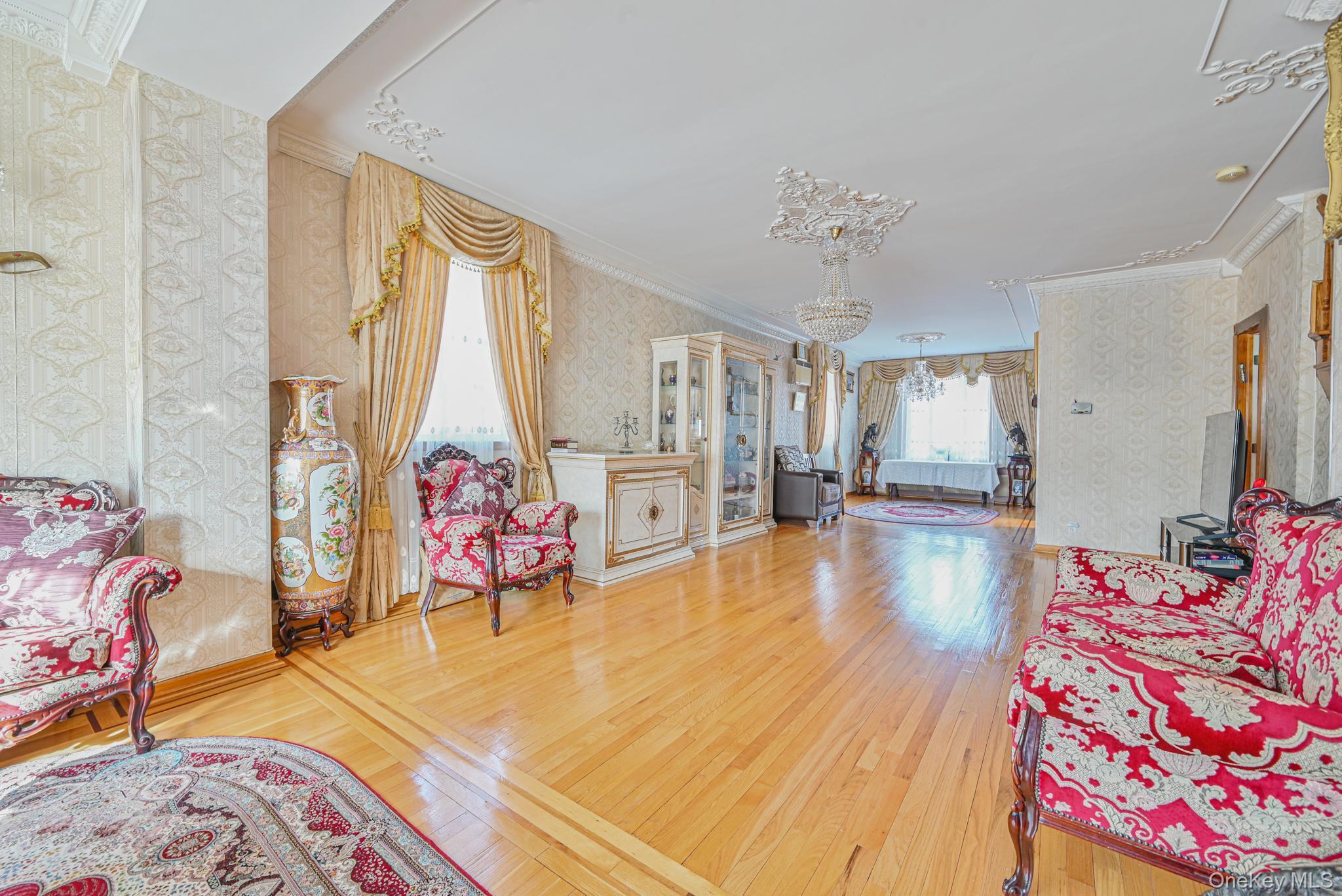 Sitting room with wallpapered walls, crown molding, and hardwood / wood-style flooring