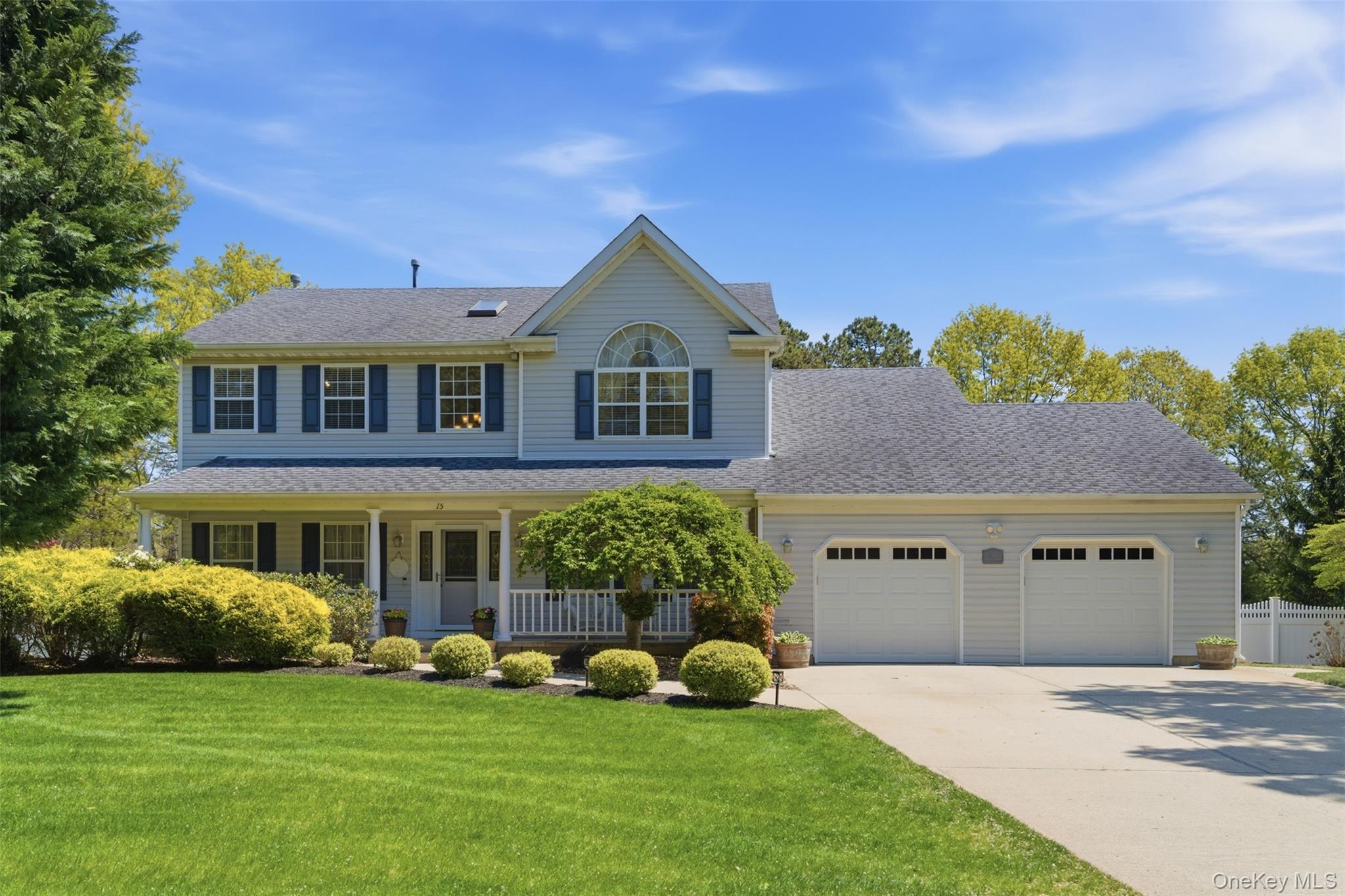 Two-story residence with a covered front porch and mature landscaping