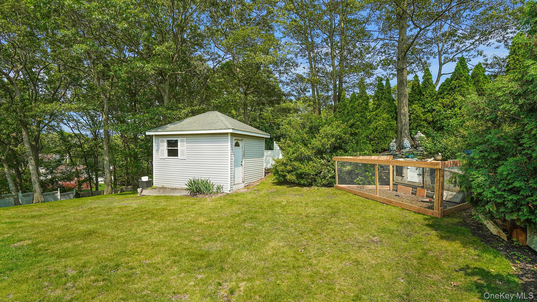 View of yard featuring a garden, a storage unit, and view of scattered trees