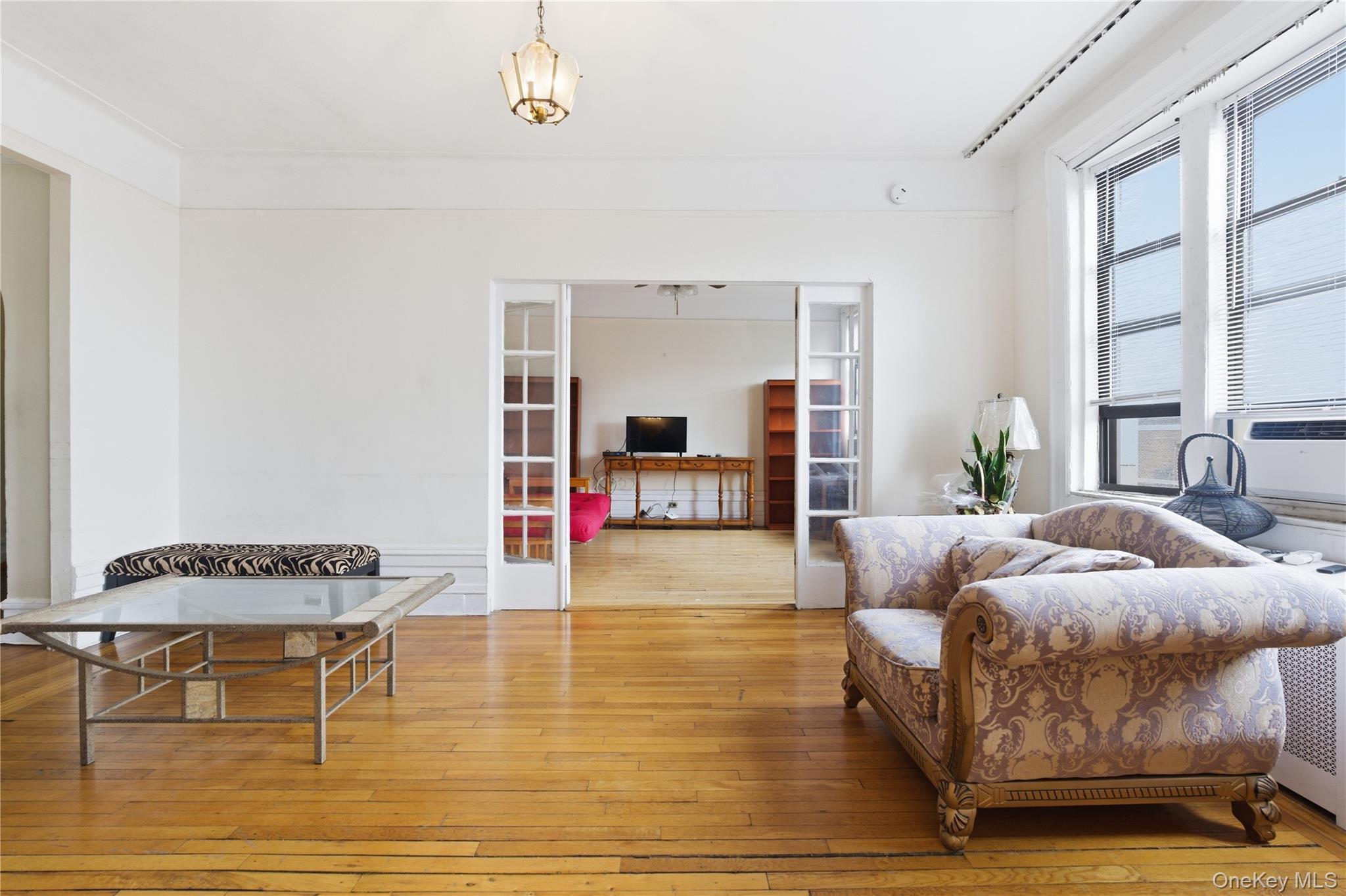 Living area featuring wood-type flooring, french doors, and cooling unit