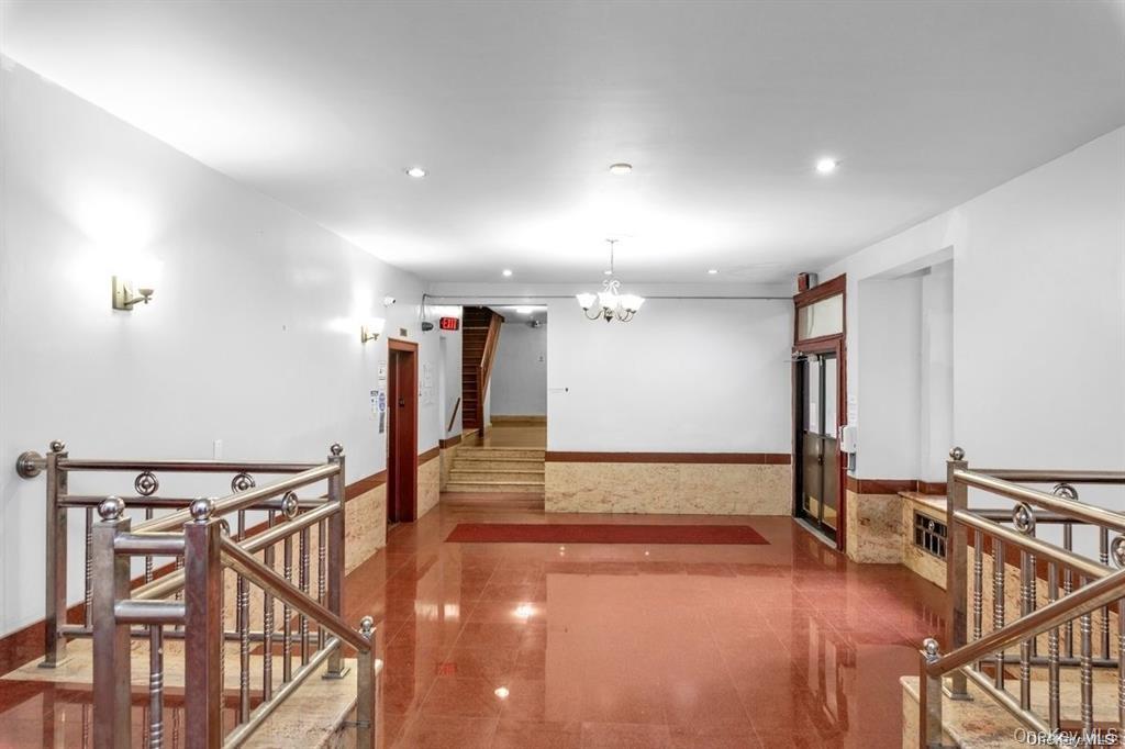 Hallway featuring a chandelier, stairs, recessed lighting, and an upstairs landing