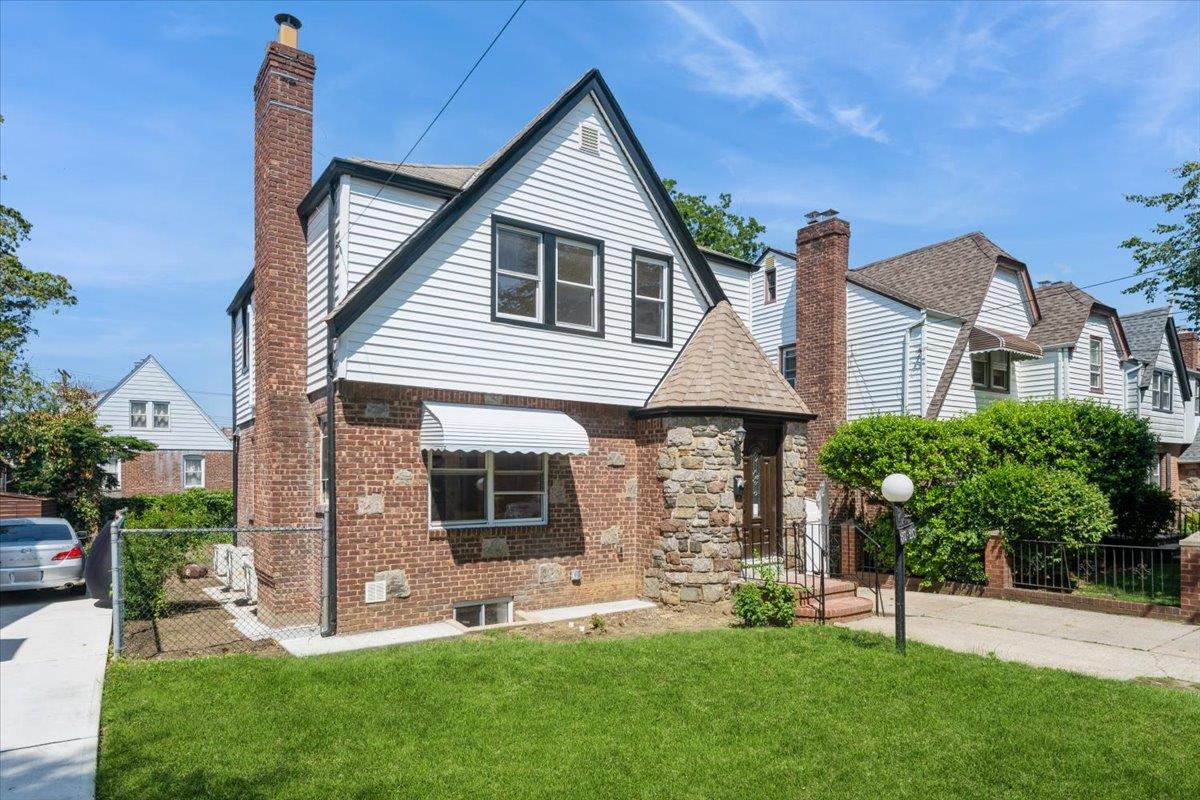 Tudor home with brick siding and a chimney