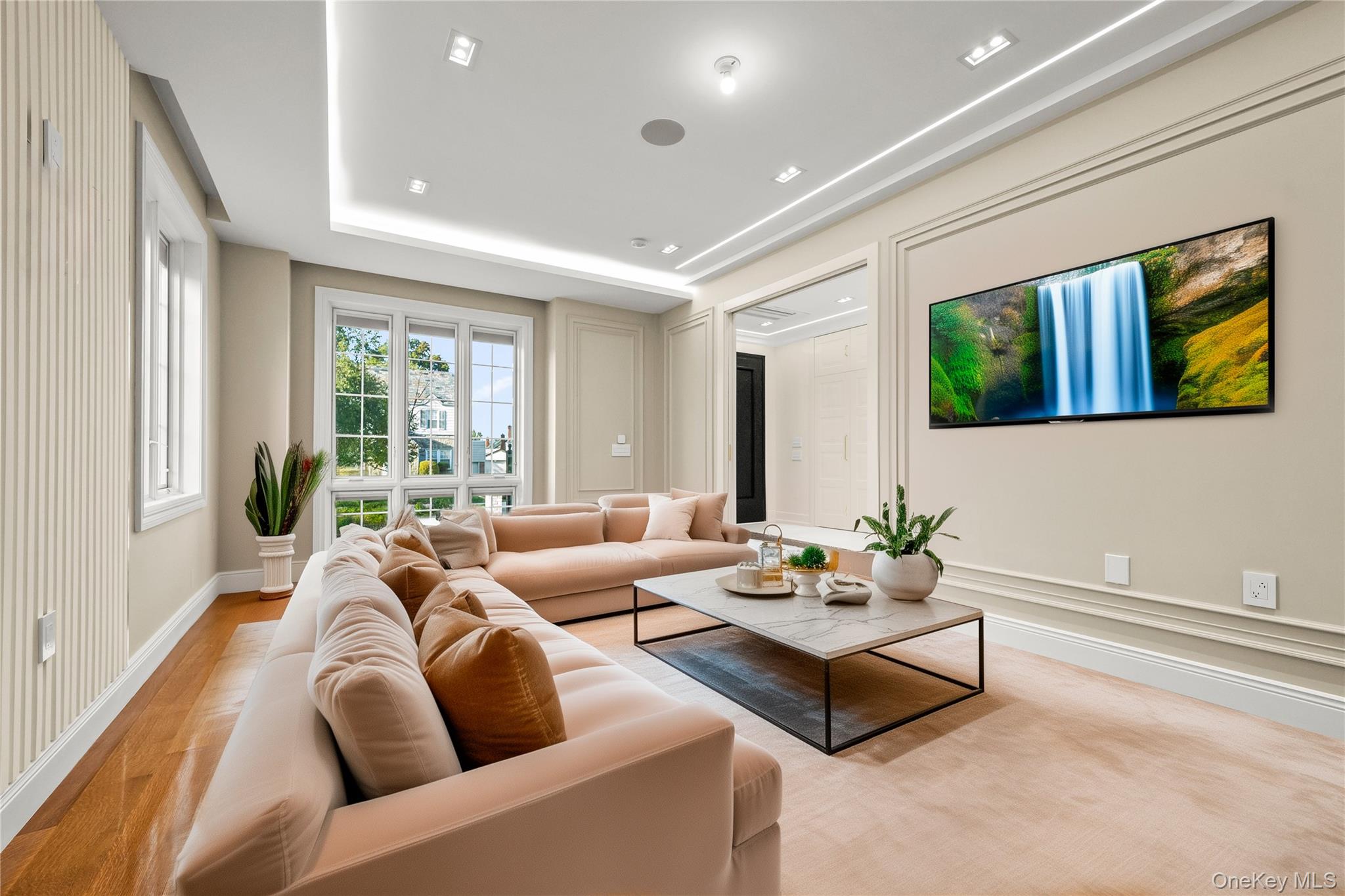 Living room featuring a raised ceiling and wood finished floors