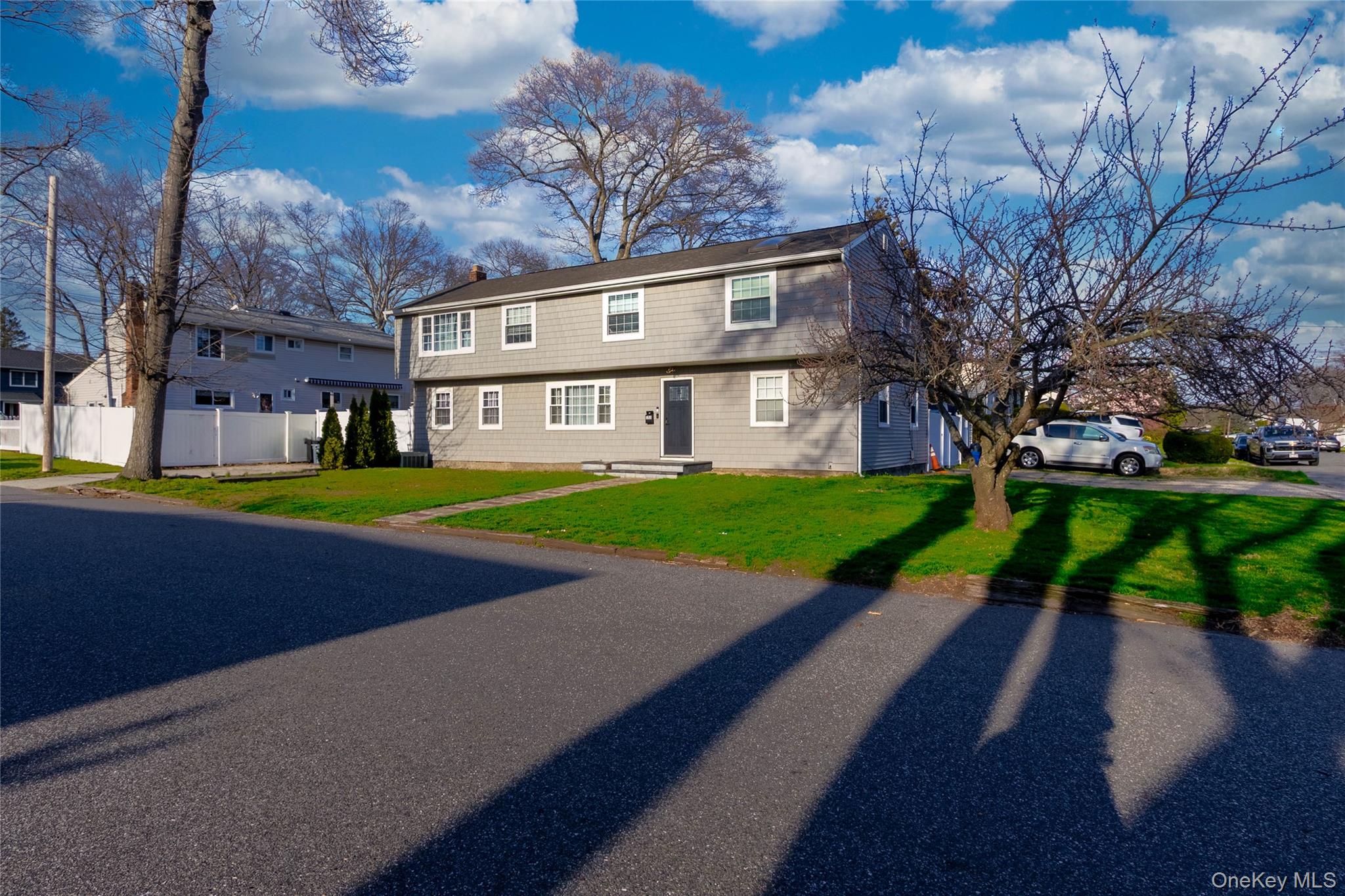 The property features a two-story exterior with light gray siding and white trim