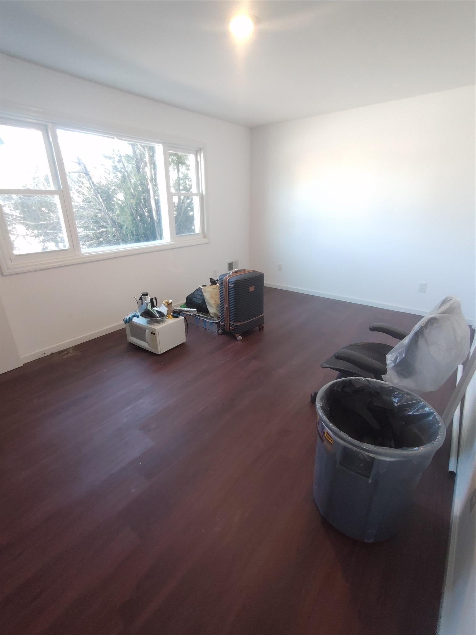 Unfurnished room with dark wood-style floors and baseboards
