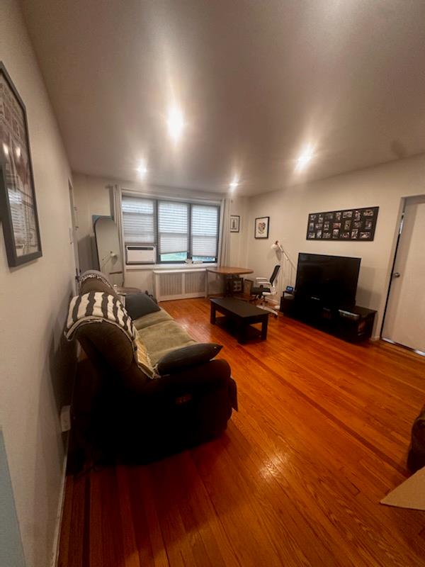 Living area with wood finished floors and radiator