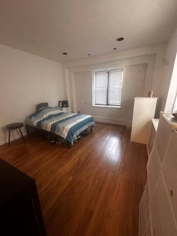 Bedroom with wood finished floors and baseboards