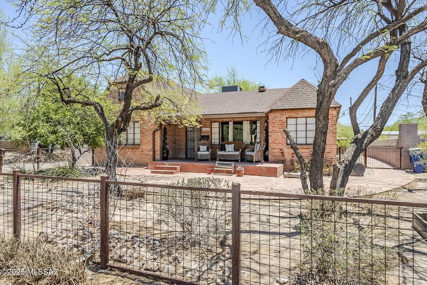 A stunning Tudor Revival residence built in 1948, nestled in the coveted Feldman's Historic District—just under a mile from the University of Arizona and downtown Tucson. This home effortlessly blends historic charm and modern amenities amid a vibrant community. With the classic Tudor Revival architecture, original hardwood floors and thick stucco-over-brick walls. Bonus spaces including a library, loft, office, rec room, and finished basement perfect for entertaining or multi-generational living. Primary suite located on the main level for convenient convenient one-floor living. Fully paid-off solar system and rainwater harvesting setup, enhancing energy and water efficiency in the desert! Detached 2-car garage and four off-street parking spaces.  Also Owned Solar!!