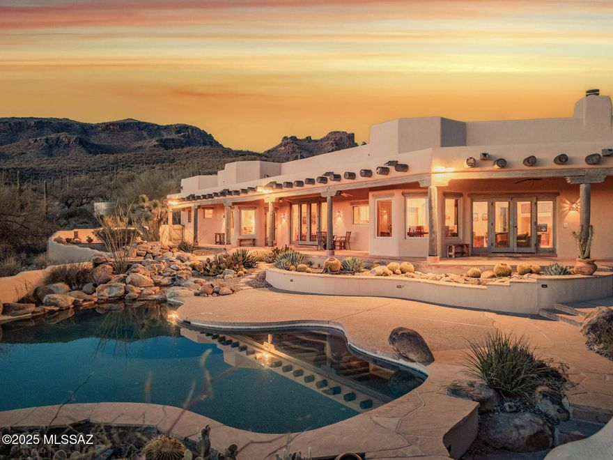 Stunning Ray Birch home in The Sanctuary. This pure Santa Fe styled home is perfectly sited to take advantage of protected panoramic city and mountain views. Hand plastered walls throughout. Viga beam ceilings finished with exquisite details: coved plaster, peeled log-shaved saguaro ribs, latillas and pinwheel design planked wood ceiling in the dining room. Rough-sawn cedar Butler doors and ultra-saltillo floors throughout. All cabinets feature rough-sawn cedar. Tiered breathtaking patios are finished in flagstone, with dramatic waterfalls connecting the pool & spa. Poolside dining/relaxing from a variety of seating areas and romantic poolside fireplace for cozy evenings.  Built-in barbecue for alfresco dining. Wrap-around porches for enjoying city lights and mountain views.