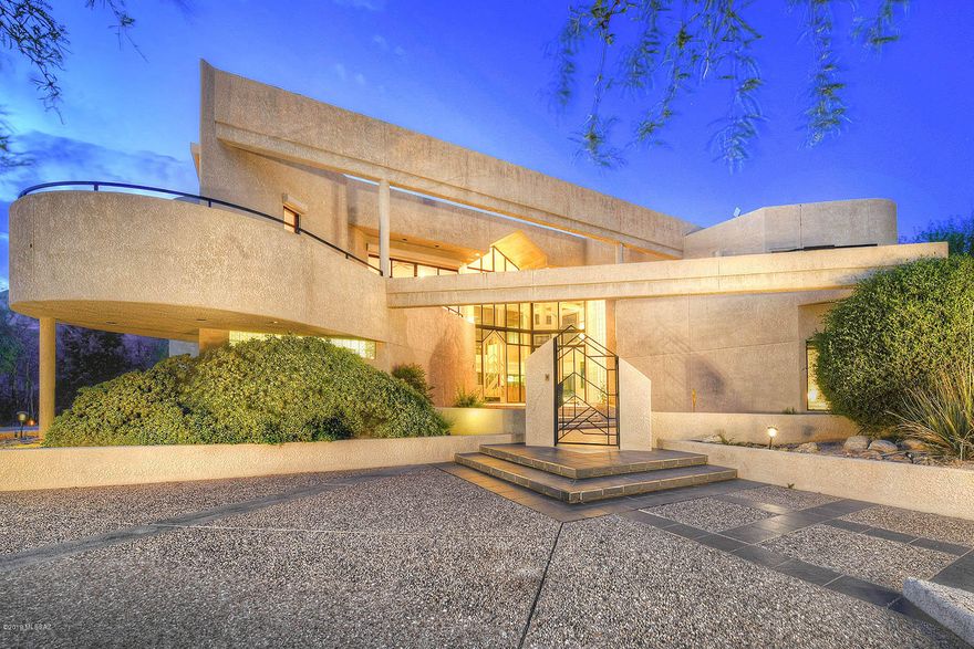 Spectacular custom home encompasses modern elegance mixed with contemporary exquisite lines.  Featuring 20 ft walls of windows, this property showcases captivating views of the Catalina Mountains. Italian Stone courtyard greets you and the open living concept allows for a variety of uses.  With over 4000 square feet inside, you will enjoy the generous open kitchen with island and built-in breakfast bench. Spiral staircase leads you to the open loft/family room with private bath. Master suite has its own laundry, large walk-in closet & balcony where you can enjoy Tucson's sparkling city lights. 3 cozy fireplaces and extra work out room.  Retreat outdoors to your north facing back yard in style with glass wall, pool & spa. Spacious 3 car garage with extra storage. One of a kind-unique home!