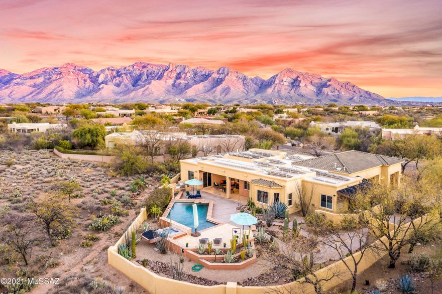 Nestled in the desirable community of Reflection Ridge, this custom 4 bdrm,3 bth solar powered (owned) home boasts timeless architecture and outstanding craftsmanship with an abundance of skylights. You'll be greeted by lush desert landscaping, eye-catching stonework, a lg covered entry. Custom ironwork double front doors welcome you into a magnificent great rm, featuring beautiful wood beams, tongue-&-groove wood plank ceilings, well-appointed gourmet kitchen, with updated appliances, granite countertops, custom backsplash. A stacked stone wall with a gas fireplace, and a wall of windows overlooking the luxurious, heated pool/Spa, outside kitchen, cactus garden, desert backdrop. The lavish owner's suite is comfortable with an inviting patio access to enjoy the breathtaking mountain views!