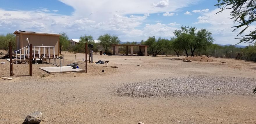 Acre lot completely fenced with 2 access gates.
All utilities onsite ready for your home.  Breath taking mountain views! Located right off the pavement close to Tucson yet near by to all your shopping needs. Acre is landscaped ready for your home or RV,  equipped with a 2 car carport and built-in barbeque and storage shed.  Enjoy the unobstructed views of the mountains from your existing viewing deck.