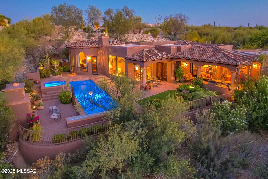 Tucked behind a hill for ultimate privacy, this beautifully maintained 3 bedroom, 4 bath custom home in guard-gated Hacienda Del Sol Estates offers sweeping Catalina Mountain views and a peaceful, secluded setting. Spanning 3,643 sq. ft., the home features a thoughtfully designed floorplan with stone and wood flooring throughout, high ceilings, and generous natural light. The spacious living room centers around a charming fireplace and large picture windows that frame the mountain views. The chef's kitchen boasts granite countertops, a 5-burner Thermador cooktop, wine refrigerator, and ample storage. A formal dining room, separate study with custom cabinetry, and en-suite guest bedrooms add to the appeal. The oversized 3-car garage includes a storage room, workshop sink, and two
