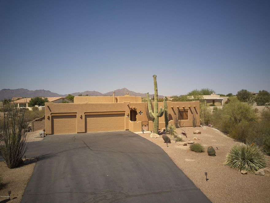 Welcome to this spectacular one owner home, preserved as if it were just built. Walk through the elegant courtyard with spectacular views of the mountains and the city. Walk into the open floor plan with beautiful Saltillo tile, large family room with fireplace and open kitchen with abundance of storage. The lower cabinets in this kitchen offer slide-out shelves,enlarged built-in pantrys. Gracious sized master bedroom with beautiful views of the backyard. Large master bath with his and hers vanities, large garden tub and separate shower.3 spacious guest bedrooms and large guest full bath with dual vanities. All bedrooms have  upgraded Berber carpet. Backyard offers a beautiful large covered open beam patio married with brick pavers. Facing the amazing Tucson mountains with the best sunsets
