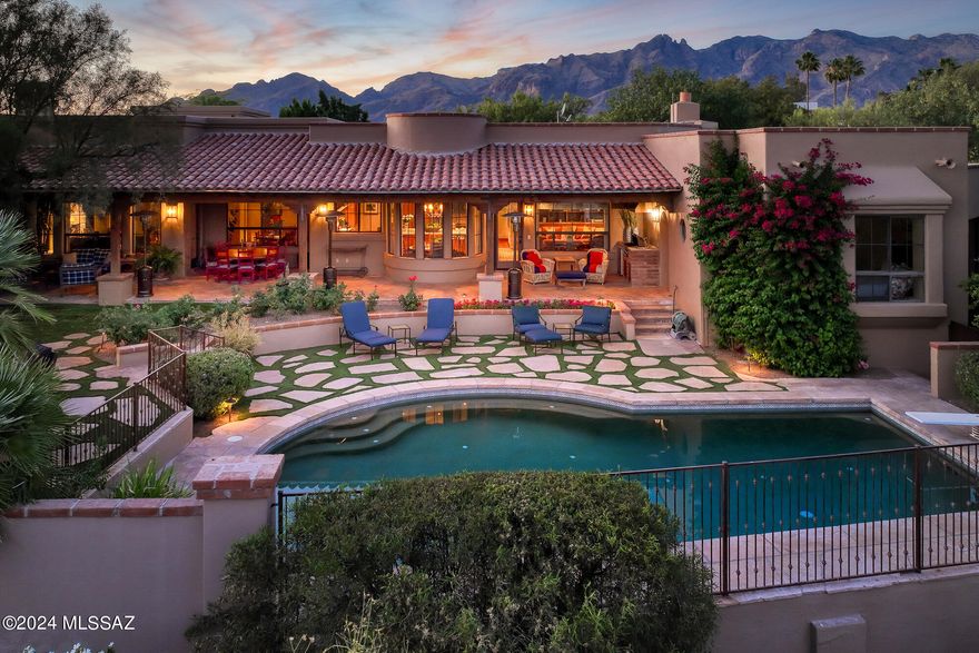 Quintessential Tucson home with a guest casita situated on an elevated homesite in the heart of the Old Foothills. Experience a private & secluded sanctuary-style retreat with expansive views of the city, iconic Tucson sunsets, & mountains in every direction without sacrificing proximity to the U of A, the Loop,, the best restaurants, shopping, &  more. This meticulously remodeled home reflects a unified vision executed to perfection with the assistance of acclaimed interior designer Linda Robinson. The result is a flawless masterpiece of curated materials that envelop you in livable luxury & understated sophistication. The shade of a canopy of mesquite trees produces an enchanting introduction & a romantic ambiance that sets this property apart...continued... Intentional architectural details, brick-capped smooth stucco, flagstone walkways, wood-lined red-tile porches, & distinctive windows come together to present a modernized version of a classic Tucson home. The split-level floor plan separates the main level of the house with a refined kitchen completed with a masterful combination of the finest materials, five en-suite bedrooms (including the separate guest casita), an office, a library & 2 powder rooms from the lower level designed purely for recreation & entertainment. The lower level includes a game/media room with a wet bar & bathroom, a fully equipped workout room, an oversized storage closet & a covered patio that leads to the newly finished & lit pickleball/basketball court. The indoor & outdoor living spaces flow seamlessly with a series of verandas & dynamic spaces that encourage stepping outside to take in the views & the beauty of the natural surroundings at any time of day. In the foreground of panoramic views of the city & mountains surrounding the valley is a resort-style backyard designed for small or large-scale entertaining with an extensive covered patio, outdoor kitchen, flourishing landscape, a pebble-tec pool, & an outdoor fireplace for guests to gather on a cool winter night. This prime foothills location offers District #16 schools.  Convenient to world-class golf resorts & country clubs, hiking trails in the Catalina Mountains, the Loop- a 133-mile connected bike path, the St. Phillip's Plaza/weekly farmers markets, Trader Joe's, yoga & CrossFit studios, and much more. 
Main level:
On the main floor: The foyer sets the tone with a dramatically high ceiling adorned with hand-hewn beams, walls finished in Venetian plaster & hardwood floors that carry throughout the home. Just off the entry is a beautifully finished powder room with Santa Barbara-style tile wainscoting & refined custom finishes & two large en-suite bedrooms with walk-in closets. Behind the beautiful imported double doors off the entry, you will discover a library & reading room, another ensuite bedroom & stairs down to the lower level. The exquisite formal living room houses a grand piano & stone-covered fireplace flanked by built-in shelving with beautiful wooden doors. A vaulted barrel ceiling distinguishes the adjacent formal dining room, designed for hosting friends & family for any occasion. The exceptional kitchen is a light-filled timeless work of art that opens to a cozy family room with a fireplace & a breakfast nook perfect for informal dining. The kitchen is completed with the finest materials, including imported brick flooring, Sub-Zero & Wolf appliances, hand-crafted cabinetry, high-quality hardware, a one-of-a-kind hood vent, & a farm sink overlooking the lush backyard, pool & city views. The large center island that anchors the space has a honed quartz countertop, a prep sink, a wine refrigerator & beverage drawers. A custom wet bar area within the kitchen provides additional storage for glassware & space for guests to help themselves to drinks. A second, nearby powder room is conveniently placed for guests The kitchen/family room area effortlessly flows to the herringbone pattern brick patio. An outdoor kitchen area with a built-in BBQ, sink & refrigerator is just steps from the kitchen. The en-suite guest casita with a private entrance is nearby. The impressive covered patio extends the length of the back of the house (1000 sf of covered patio), providing plenty of space for outdoor living, dining &  large-scale entertaining. The resort-like backyard boasts a pebble-tec pool surrounded by flagstone & grass, a kiva fireplace with plenty of room for seating, a large grassy area, lush, mature landscaping & sensational views of the twinkling city lights below.  The master suite wing offers supreme privacy with a separate, private hallway leading to an office with handcrafted built-in shelves & cabinets & the luxurious master bedroom with a fireplace, a large private veranda & magnificent views. The spacious master bathroom has it all: a large window that captures the desert & valley views & streams in abundant natural light, dual vanities, a soaking tub, a separate shower & a big walk-in closet. The spacious, light & bright laundry room with a sink has abundant cabinets & counter space. The oversized 3-car garage with custom metal doors has two large storage closets & a door to the backyard & guest casita, allowing guests to privately access the casita when parking in the garage. 

Lower Level:
Designed purely for recreation & entertainment, the lower level of the home begins with a large open room with high, wood-beamed ceilings, a powder room & a wet bar with a beverage & wine refrigerator. The game room area is large enough for a pool table & the media room with custom wood built-ins has room for plenty of seating. A separate, fully equipped exercise room is the perfect place to get in a full workout at home. The oversized storage closet on the lower level provides ample space for all of your holiday decorations, seasonal clothing, &  more.  The interior space transitions seamlessly to the exterior space with a covered patio perfect for enjoying a meal or watching a pickleball match on the newly finished, lit court. Host a pickleball tournament or shoot hoops day or night. A flagstone terrace above the pickleball court with a second built-in BBQ & a gas fire feature is ideally positioned for sunset & mountain views. Stairs from the terrace connect to the main level of the home. 
In the area: 
The Loop: Tucsons 133-mile connected bike path
Trader Joe's
Whole Foods
Distance to Tucson Airport: 25 minutes
Distance to the University of Arizona: 12 minutes
Distance to downtown Tucson: 15 minutes

La Paloma Country Club: 27 holes of golf, tennis, pickleball, lap pool, kids club, swim team, work-out facilities, excellent restaurants, resort pool & a plethora of activities and seasonal events.

Skyline Country Club: golf, tennis, lap pool, workout facilities, excellent restaurant, seasonal events.

La Encantada Mall: Shopping - Crate & Barrel, Pottery Barn, West Elm, Williams Sonoma, Lulu Lemon, Athleta, Vuori, Tiffany's, Blue Mercury, Kendra Scott, DryBar & much more
Restaurants & Grocery- A.J.'s Fine Foods, North Italia, Blanco, Firebirds, Ra Sushi Bar, True Food & Frost Gelato.

St. Phillip's Plaza: Weekly farmers market, live music & more.
Restaurants- Ren Coffeehouse & Bakery, Reforma Modern Mexican, Proof Pizza & Pasta, Pure Love Juice, Union Public House & Arizona Wine Collective.
Health & Fitness- F45 Training, Yoga Pod, Bodyworks Pilates & Revolve Cycling
Shops- W Boutique, Alfonso Oils, & Shop Klio

Joesler Village:
Restaurants- PF Changs, Sullivan's, Zin Burger, & Seis Kitchen

Campbell Plaza: 
Restaurants- Dough Bird & Flower Child

Nearby Hiking Trails:
Pima Canyon Trail
Campbell Avenue Trail
Finger Rock Trail
Ventana Canyon Trail 
Sabino Canyon Recreation Center


Schools:
Located in Highly-Rated Catalina Foothills District #16 schools. Some area Charter Schools include Basis, Lehman Academy of Excellence, Khalsa Montessori School, & the International School of Tucson . Some area private schools include Pusch Ridge Christian Academy K-12, Castlehill Country Day School Pre-K to 5th, the Waldorf School newborn-8, St. Cyril's K-8, Salpointe Catholic HS, the Gregory School 5-12.
