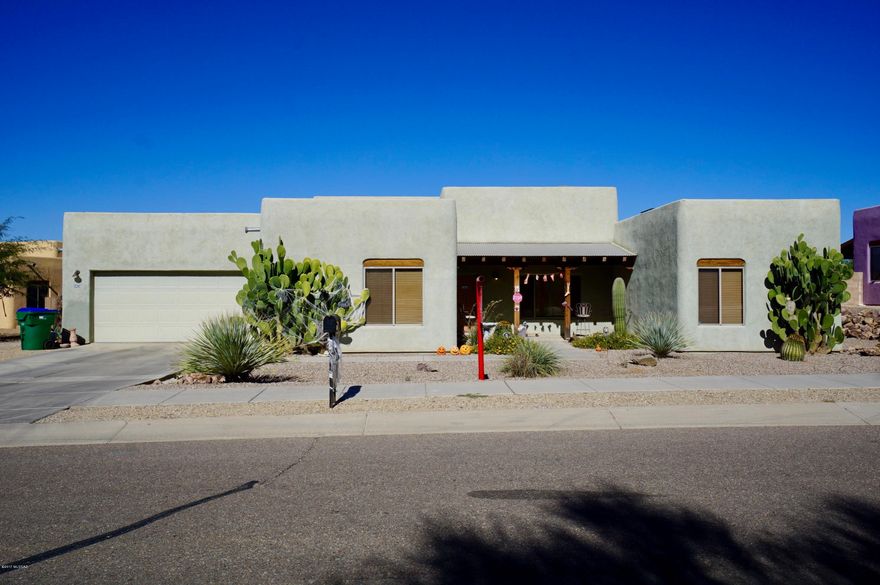 Enjoy a touch of the Southwest in this Santa Fe style TJ Bednar home in Eagle Point Estates. Custom wood beamed ceilings, Saltillo tile floors grace all main areas. Inviting beehive fireplace in living room. Kitchen with breakfast bar, upgraded cabinets, tile counter tops and backsplash. Spacious master suite, split bedroom floor plan, 3 Bedrooms, 2 Baths. Spacious enclosed backyard with covered patio and gas BBQ stub. Tucson Mountain views. 2-Car garage. Convenient to I-19. Clean and move in ready!