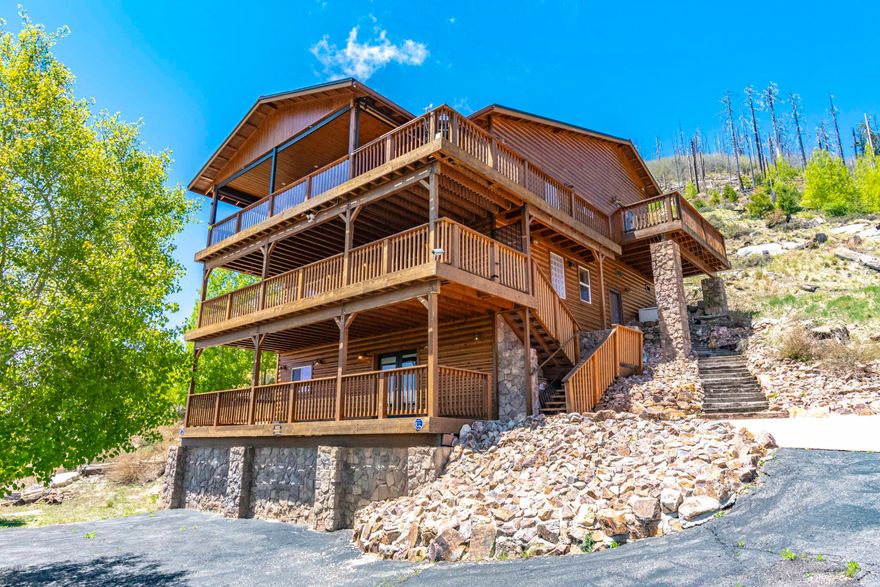 Stunning hillside home overlooking Summerhaven offers breathtaking views of the town and surrounding hills. This custom built beauty features 5br(3bedrooms plus a 4th loft bedroom and efficiency suite sleeping area) , 4ba with 3fireplaces inside (2gas one electric) and another fireplace on the 3rd deck outside. This decks also features retractable translucent sides so you can enjoy the outdoors year-'round.  The first floor is a guest efficiency suite with bar/kitchenette, electric FP, full bath and a large living area that doubles as a 5th bedroom. The second floor is a great room with a fireplace, office/BR and spiral staircase that leads to the third floor where the 3rd fireplace, living area, dining room and kitchen are located. There is a living room loft on the 3rd floor and steps to another level where the rest of the bedrooms can be found.  One is the spacious master bedroom featuring its outdoor deck that wraps around to the to the main deck, and a master bath with heated floors and a Jacuzzi tub.  The second bedroom features a loft for a additional, separate sleeping area.  All 3 floors have enormous patio decks.  There are stairs connecting all floors as well as an elevator.  There is a generator to provide power when electric service is disrupted.  This home is situated on 2 lots, giving you twice the frontage space and plenty of paved parking.  The road is county maintained, so you can enjoy your home even when the snow gets deep.  There is a recreational toy garage, workshop and loads of storage.  Home is pre-wired for phone, cable & Ethernet and includes intercom and security systems.
See specific details under documents tab.