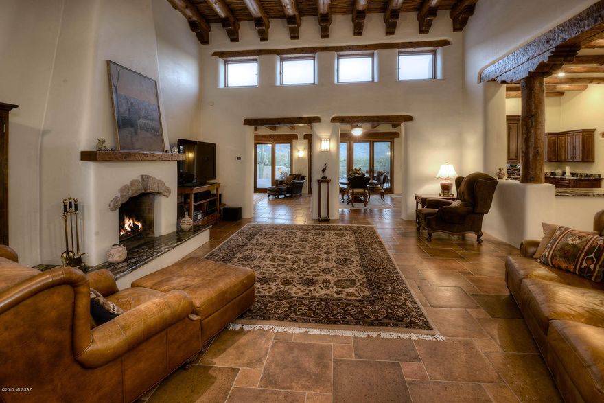 Stunningly remodeled Mark Butler mud adobe Santa Fe masterpiece home on 20 acres (approximately 17 are a dedicated conservation easement) with privacy, sweeping Rincon mountain views and adjacent to the spring fed La Cebadilla lake.  Courtyard entry leads to great room with soaring viga beamed and hand carved corbel ceiling, floor to ceiling fireplace and rustic earth tone floors.  Remodeled and expanded kitchen features granite counters and stainless steel appliances   Family room adjacent to great room offers walls of windows, rear patio and mountain views.  Gloriously remodeled master suite and bath has viga beamed and saguaro ribbed ceiling and beehive fireplace.  Expansive rear porch and yard features   hand carved beamed ceiling and rear yard with saguaros. Rear yard features pool, kiva fireplace & brick pavers. Full two bedroom guest house with kitchen.Main house has three garage spaces and don't miss the two car detached garage. Plenty of room for horses. Horse trails from property to Saguaro National Park and National forest.   Don't miss the incomparable and rare find.