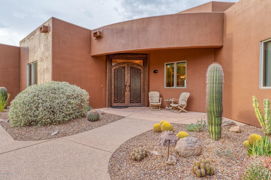 Welcome Home to this Gorgeous Highly Sought After Private Community, Saguaro Cliffs. This Multi-Generational Home Provides Privacy and Space for Generations to Come.  Separate Living Quarters Connected by Shared Laundry & Vaulted Ceilings. Freshly Painted Exterior as you Step into the Grand Entryway, Double Front Iron Doors. Picture windows w/Views of the Catalinas & Rincon Mountains. Main Home featuring Oversized Master Suite, Guest Bedroom, Office w/ Built in Custom Cabinetry & 2 Bathrooms. Great Room, Chefs Kitchen with Built-in Subzero Refrigerator, Wolf 6 Burner Range, Granite Countertops ready for Gourmet Cooking. Attached Casita 2 Bedroom Suite Boasts Vaulted Ceilings, Private Garage, Oversized Storage/Craft Room, 2 Bath, Private Covered Patio and Endless Views.  Views from your East Facing Backyard Oasis, with plenty of room to Entertain by the Handicap Accessible Pool, Built-In BBQ & Outdoor Kitchen along w/ 2 Covered Patios and Room for a Jacuzzi. Solar System Leased and Paid for through 2030, Maintenance Free Solar Panels and Extremely Low Utility Bills make this an added Bonus. Don't miss the Opportunity to Own!