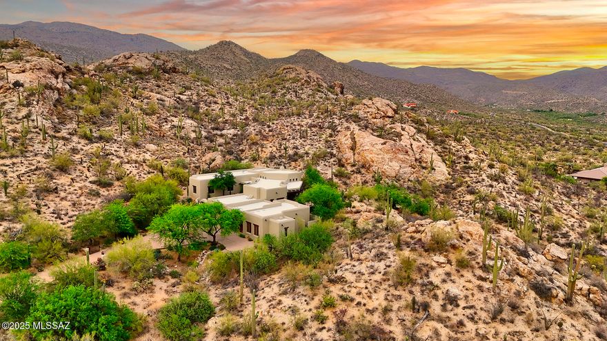 More stunning than words can describe, this architecturally significant mud adobe stucco, Santa Fe-style home by master home builder Mark Butler, leaves no details left to the imagination.  Perched on a hilltop, nestled into the Catalina Mountains with stellar mountain views on 5.93 glorious saguaro studded acres. A long and winding drive leads to the arched entry with wooden lintel and saguaro ribbed gate into the courtyard with fountain and flagstone floor.  If you like southwestern, Santa Fe and rustic, there are no rooms better than this great room — soaring viga ceiling with skip-pealed latillas, hand-adzed lintels and corbels, a charming kiva fireplace, expansive picture windows with enviable Rincon Mountain views.  The generous southwestern-style kitchen offers a beamed ceiling, ceiling, a beehive fireplace with banco seating, Talavera tile counters, saguaro ribbed cabinetry, large center island with a 5-burner gas stove, and a light & bright breakfast nook with a beamed and saguaro ribbed ceiling.  Featured in the main house are 3 bedrooms (den/study could be 3rd bedroom) including a gracious primary suite with dual vanities, soaking tub, separate shower, and dual walk-in closets.  The charming casita offers beamed ceilings, viga columns and corbels, kitchenette and world-class wine cellar.  The glorious and freshly painted exterior has an expansive back porch, a spool built into the hillside and flagstone floors.  Two-car garage, one-car carport, charm, character, unmatched quality, privacy, views and timeless design await you.