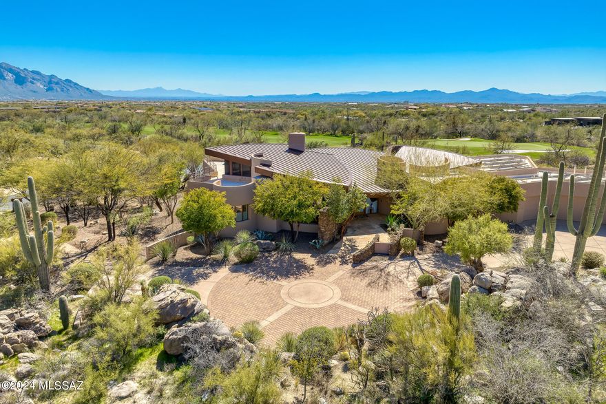 Stunning & dramatic soft contemporary designed by renowned Tucson architect Kevin Howard provides seclusion & sweeping Catalina views across 11th fairway of world-class Stone Canyon golf course. Floor-to-ceiling windows, Limestone floors & high-end finishes all infused with warmth via stone accents to create an inviting yet dramatic luxury residence. Main house (4,343 SF) has fabulous Great Room w/metal clad Fpl, Wetbar w/Wine Ref, Luxury Kitchen, Powder Rm, gorgeous Primary, Guest Suite, large Den & Loft Office w/large deck & views to Tucson. Guest House (542 SF) includes 2nd Guest Suite w/sep Living Area & Kitchenette. Enchanting yard w/negative edge Pool/Spa, misting system. Covered outdoor kitchen w/Fpl offers multiple entertainment areas and mesmerizing views. Club Membership req'd.