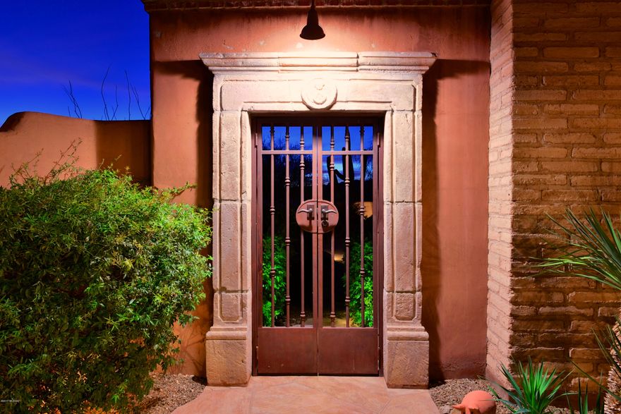 The indoor/outdoor lifestyle of this James Gray, custom built mud adobe secluded home is captivating. Located in luxurious gated Honey Bee Canyon Estates, this home was built to capture the spectacular views of the Santa Catalina, Tortolita Mountains and city lights. The chef inspired kitchen has a 6 burner Wolf cooktop, Sub-Zero refrigerator, centerpiece hood vent, soap stone sink and custom cabinetry. Wine enthusiasts will enjoy the 2,000 bottle custom wine cellar. Impeccable details throughout; San Miguel ironwork, teak columns from India and Cantera Stone details. The expansive outdoor living space includes a spacious spa, fireplace, outdoor kitchen and multiple places to gather for dinner parties.