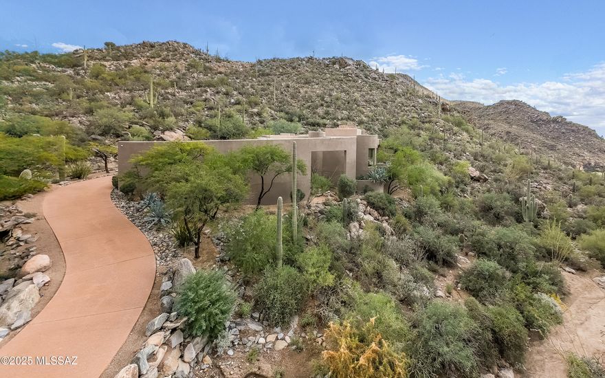 Come experience a higher level of luxury living. Welcome to this stunning Kevin Howard custom designed residence w/outstanding craftsmanship, bold style and engaging design situated on 2.5± acres within the Tortolita Mountains. You are surrounded by breathtaking mountain views. The home features elegant curvature architecture, spacious great room w/brick fireplace and floor to ceiling windows and doors. Guests will enjoy an expansive patio for large entertaining events.  The chef's kitchen includes a massive island, alder cabinets, buffet, walk-in pantry, & dining nook w/mesmerizing views. Very spacious office can double as a private 4th bedroom en-suite. A tranquil & relaxing primary suite boasts travertine floors, walk-in shower, lengthy dual sinks & access to private spa & great views! Dove Mountain is a 2025 Readers' Choice contender for Best Master-Planned Community. Enjoy Dove Mountain's world class golfing, outstanding hiking trails, biking paths, state of the art sports club, casual and fine dining options. Easy access to theatre and the arts, University of Arizona campus and multiple airports. Sonoran Desert living at Dove Mountain means enjoying outdoor living at its best.  Nearly 1/3rd of Dove Mountain's 6,200 acres of desert splendor is being kept in perpetuity as natural open space.  More than 10 miles of its boundary borders other formal preserves or Arizona State Trust-owned mountain land. That lovely "cooing" sound you hear in the evenings may be the gentle Inca Doves which live in the area and give this elegant enclave its name. Pima County's 3,000-acre Tortolita Mountain Park borders Dove Mountain to the north.  To the south is the 2,400-acre Tortolita Preserve, with its outstanding biking and hiking trails, designated to be permanently sustained by the City of Marana and the State of Arizona. Nestled in the beautiful Tortolita Mountain Foothills, Dove Mountain is perhaps the epitome of Southwest desert living. The temperate climate allows residents to enjoy an indoor/outdoor lifestyle virtually all year-round, not just in in the fall, winter and spring seasons for which the region is famous. The wildlife of Dove Mountain is fascinating. The Sonoran Desert is home to species like the Great Horned Owl, the Golden Eagle, the Black-chinned Hummingbird, Gambel's Quail, the Hooded Oriole and the Cactus Wren, Arizona's official bird. The lifestyle here is fascinating, mesmerizing, graceful, luxurious, peaceful and fun.Perhaps your own Dove Mountain story is just beginning at THIS lovely, fine custom home. Call for a private showing.
