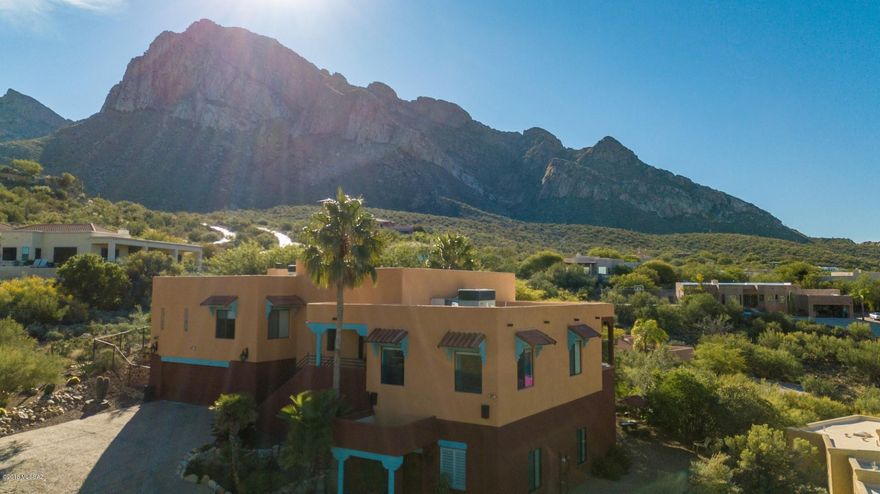 BROKER HOME TOUR WINNER w/HUGE price improvement! Enjoy panoramic views surrounding this unique Hacienda nestled at the 8th tee of the prestigious El Conquistador Hilton Resort. Spacious great room w/ custom paint, wood beam ceilings, custom fireplace, built-in book shelves, & elevator! Custom kitchen w/ saguaro cabinets, GE Monogram refrigerator, Jennair induction cooktop + oven, granite countertops & sink, breakfast bar, & large pantry.  Stunning sunset views from extended covered balcony patio w/ custom shades & misting system. Grand master suite w/ private Juliet balcony, see through fireplace to private en suite w/ Bain Ultra JetAir Tub. Vintage theater room w/ Elite Screen. Game/gym room w/ kitchenette. Double tandem garage holds 4 vehicles.  Back yard oasis boasts a pebble tech pool rock waterfall, beautiful mature landscaping complete w/ citrus trees & cacti.  Separate entry guest Casita w/ full kitchen, living & dining areas, bedroom, walk-in closet, bath, and laundry!  Resort style living w/ NO HOA! RV parking, breath taking views of the city lights, mountains, and golf course!  Unlimited potential- multigenerational, home business, B&B-resort zoned, and so much more! Contact listing brokers for your private tour.  True Tucson gem!