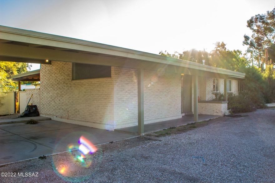 he home is set on the corner of the street with a large wrap around driveway and has a two car carport. When you enter, the living room is to your left and the kitchen to your right. The living room has lots of large open windows for great natural lighting and features a stunning fireplace and sliding glass doors to the back porch. Through the living room is the family room that is slightly bigger, has double doors for the laundry room area, and a wall of windows that looks out onto the back porch. The kitchen includes all stainless steel appliances:refrigerator, microwave, dishwasher, and stove. Through the family room down the back hall are the 3 bedrooms and 2 bathrooms.Outside is nice sized covered patio and spacious backyard.The home includes two hot water heaters, AC and is on septic