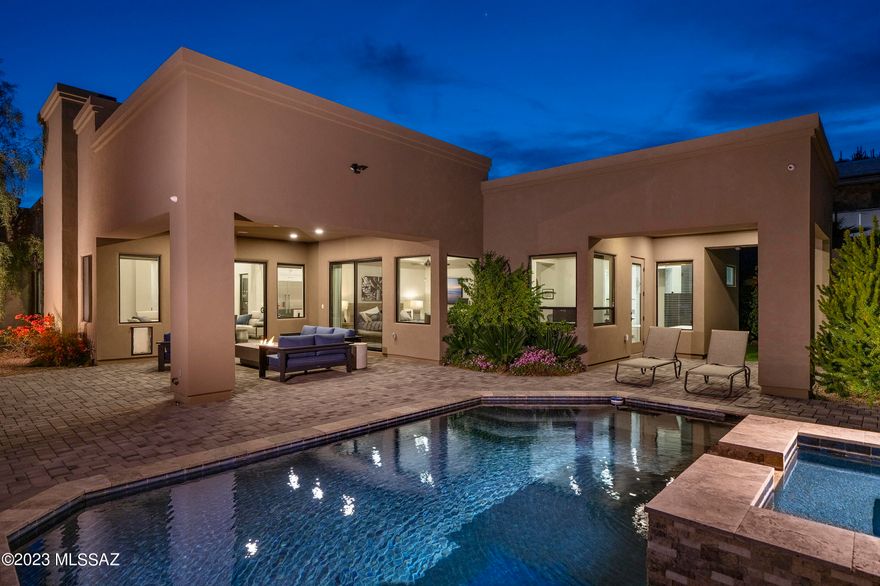 Nestled in Tucson's scenic foothills, this ultra modern home embodies luxurious living.  The open floorplan is flooded with natural light, blending elegance and tranquility.  The gourmet kitchen with generous waterfall island, hidden pantry, adjacent wine cellar and outside grilling station combine for an entertainer's dream.  Den off the primary and all bedrooms with en suite baths for privacy.   Add that pool, spa, yard and 3 car garage and this could be the one.