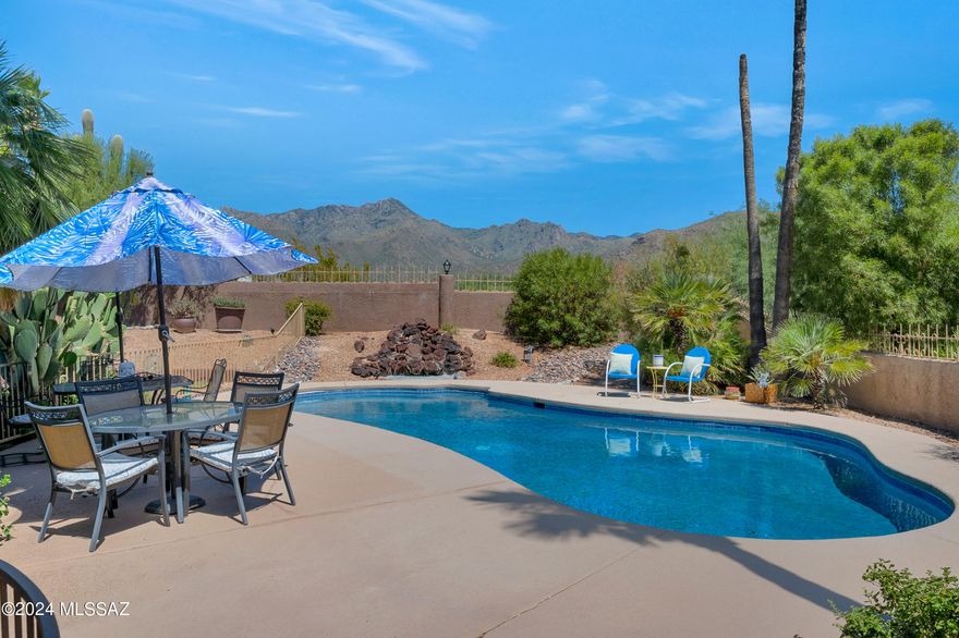 Nestled in the highly desirable foothills, this gorgeous five-bedroom, three-bathroom home offers a perfect blend of elegance and comfort. Step into the beautiful foyer, where vaulted ceilings and abundant natural light create an inviting atmosphere. The home features stunning hardwood floors, round arches, and plantation shutters in the formal living room and bedrooms. The chef's kitchen is a dream, boasting quartz countertops, a dry bar with a beverage fridge, and ample counter space illuminated by a skylight. Two dining areas provide space for both casual and formal meals, while the cozy living area, complete with a gas-burning brick fireplace and sliding doors to the backyard, is perfect for family gatherings.The oversized primary bedroom is a true retreat, with two closets a spa-like ensuite featuring a walk-in shower, soaking tub, dual vanity with marble countertops, and a skylight. Enjoy private access to the backyard from the primary bedroom through sliding doors. The outdoor space is a haven, featuring an immaculately maintained sparkling pool, lush grass lawn, covered patio, and beautiful landscaping with palm trees, all set against breathtaking mountain views. Additional features include a newly replaced roof, a recently repaved driveway, a new irrigation system, a Tuff Shed for extra storage, and updated exterior lighting. This home is carpet-free, with plenty of storage throughout, and is close to Ventana Village shopping plaza, great schools, fine dining, shopping, and hiking trails. This home is move-in ready and waiting for its new owner to enjoy all its incredible features.