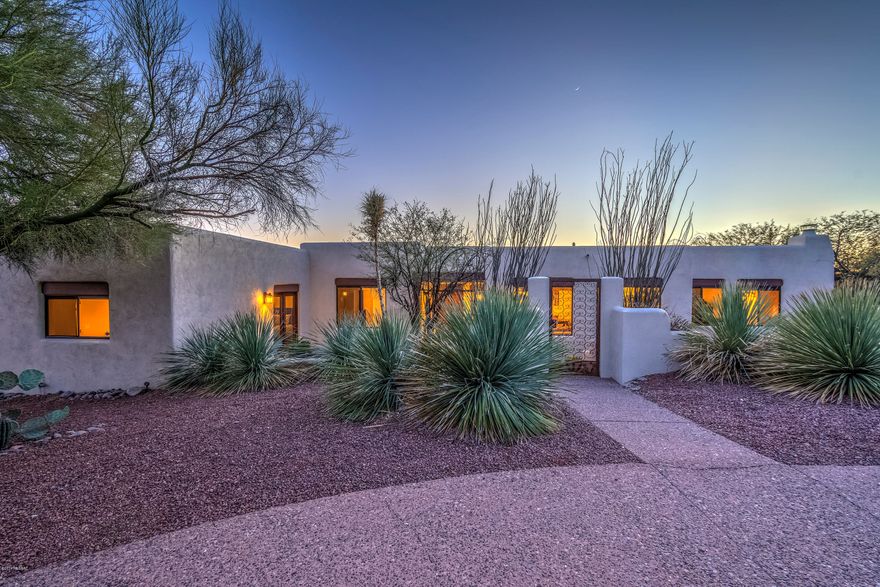 Beautifully warm and welcoming UPDATED custom Santa Fe situated on TWO ACRES, with TWO MASTER RETREATS and two additional bedrooms, in Catalina Foothills Estates 9, one of Tucson’s most popular foothills neighborhoods. Enter the beautifully gated front courtyard and find yourself in comfortable elegance, where high ceilings and expansive windows bring the beauty of the desert into the open living spaces of the home. Relax or entertain in the formal living and dining area, or in the family room with a corner kiva fireplace, wood flooring, and artfully crafted ceilings of rough hewn plank and hand peeled viga beams. Enjoy panoramic vistas of the Tucson Mountains and stunning sunsets in the wonderfully designed kitchen, featuring custom cabinetry, a spacious pantry, center island, and grani countertops. Each of the two master retreats with remodeled baths and exceptional closets, is sublime! The west retreat features full views of the Catalinas, a large seating area, separate reading corner, kiva fireplace, exquisite walk-in, travertine flooring, and french doors leading to the pool and spa. The east retreat is equally spacious, with a dressing room, and two sets of french doors, one leading to the front courtyard; the other to the beautiful park-like yard with full covered patio. Two additional bedrooms in the home each have walk in-closets and beautiful views. Add to this, gorgeous premium wood flooring, a most private pool and spa, exceptional well insulated 2x8 construction, a perfectly placed laundry, extended garage with high ceilings, a circular aggregate front driveway along with a private driveway (with extra parking for guests), north-south exposure, well maintained neighborhood roadways, fine southwestern detail throughout. Whether relaxing by two outdoor fireplaces, enjoying the pool and spa with sunset as the backdrop, entertaining in the gorgeous yard with forever-sweeping views of the Catalinas, or enjoying daily walks on the gently sloping winding roadways, you'll enjoy the best that Tucson has to offer! Venture out in the morning or evening to AJ's Fine Foods and upscale shopping at La Encantada Mall or some of Tucson's premier restaurants, each less than 5 minutes away. Weekend theatre, UofA games, downtown dining and events? All are less than 20 minutes away. You will love this beautifully designed home offering the serenity and beauty of true foothills living!