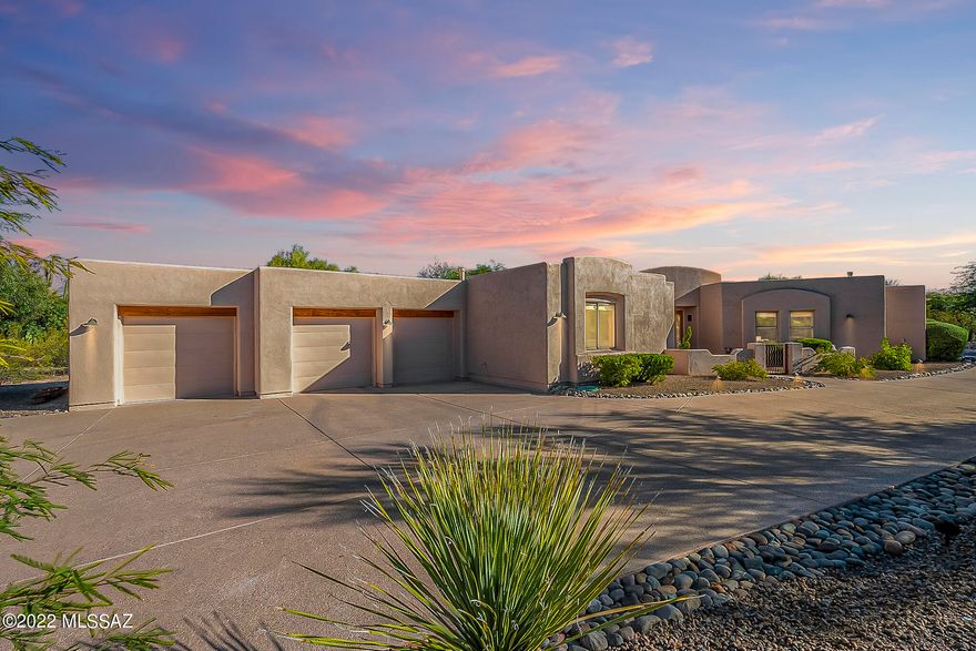 Custom Southwestern Contemporary 4bd/2.5 ba one-story home nestled on nearly an acre in desirable, gated Madera Mesa Estates in Tanque Verde Valley w/mountain views & park-like backyard setting. Enjoy shaded evenings in beautifully landscaped pool sized yard w/wrap around covered patio, brick pavers, built-in hot tub, fenced dog-run & double gate. Sprawling split bedroom plan w/open dining & living spaces, a 4th bedroom set up as an office w/storage & desk built-ins. Kitchen w/valuable storage, SS appliances, gas cooktop & large island w/granite counter. Spacious pantry & laundry, walk-in closets w/ built-ins, gas fireplace, water softener, alarm system. Oversized 3-car garage w/3 lg storage closets & set up nicely for workshop. See attached list of Features and Upgrades for more details!