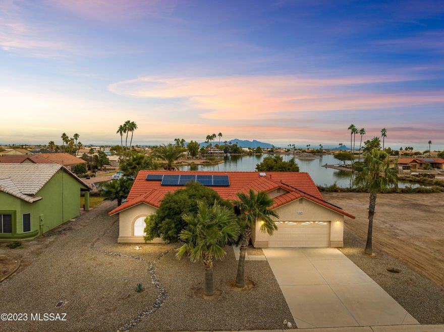 You will be charmed by this immaculate offering on Paradise Lake -- a 3-bed / 2-bath, energy-efficient home with solar panels and boat dock. Upon entering the high-ceilinged great room, a stunning view of the lake is framed by three east-facing, double slider windows. The covered back patio with sun shades, a fruit-bearing date palm, mature trees and zen sand/gravel landscaping complete your personal paradise. Features open plan kitchen with reverse osmosis, large master bedroom with walk-in closet and ensuite, dual flush toilets, HE washer and dryer. Garage contains second refrigerator, extensive shelving/storage units. 14-Seer HVAC installed 2017. Jump on this opportunity to own what many consider the BEST view on Paradise Lake!

Furniture package available; see documents for list.