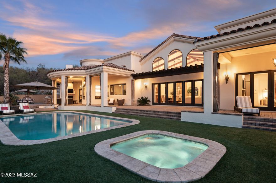 Situated on an elevated near one-acre lot, this exquisite 2006 foothills home is perfectly sited to capture the entire expanse of breathtaking Catalina Mountain views. All you need to do is absolutely nothing to move into this Mediterranean masterpiece located in a small, gated enclave of custom homes near Ventana Canyon. This sprawling, five-bedroom residence has a masterful design & thoughtful layout that spares no detail for enhancing both entertaining guests & everyday living. The 5900 sf main level is  without any steps, the stairs that lead down to a separate 900 sf living quarters w/ private entrance, kitchenette, large living area & bed & bath are the only steps in the house. Everything you need to live in this exceptional home is on the main floor, downstairs is a bonus area. The ever-present quality and attention to detail give way to an experience that merges the spellbinding beauty of the Sonoran Desert with the feeling of a hillside European Villa.  Enter through an impressive foyer that leads to the great room with a massive wall of windows that showcases the unobstructed mountain views to the north. This magnificent room with a formal dining area has soaring 21' foot wood beamed ceilings, decorative hand-made wrought iron panels, a grand fireplace covered in antique-colored concrete, and hand-carved hardwood plank floors. An exquisite library with custom built-in shelving creates an interesting use of space off of the great room. A temperature controlled 750 bottle wine room and a powder room for guests create the ultimate space for entertaining. The island in the kitchen is the centerpiece of this dream kitchen, outfitted with Sub-Zero, Wolf, and Miele appliances, custom cabinets, tile backsplash, and large windows that frame the mountains & pour in natural light. The kitchen is open to the family room with a gas fireplace, informal dining area, and distinctive Italian-fired Terra Cotta Flooring.  Butler's pantry with sink connects the formal dining area in the great room to the kitchen area.  The master suite occupies the west wing of the home features a large bedroom with a gas fireplace and his and hers master bathrooms, hers with a separate shower, a claw foot tub with incredible mountain views, and new storage cabinets, and a large walk-in closet. His bathroom has a steam shower and a walk-in closet.  Three ample-sized en-suite bedrooms occupy the east wing of the home, with a unifying bonus area that is a perfect playroom for kids or a place to hang out and watch TV. Outside is a true oasis with a heated pool and a spa with all new equipment that is surrounded by low-care turf. Patios lined with pavers provide multiple spaces to take in the glory of the mountains, beautiful sunrise or sunset, or watch the twinkling lights at night. A casual space under the covered patio is an outdoor living room with a gas fireplace and television. It is located next to the outdoor kitchen with a built-in Lynx BBQ, sink, refrigerator, and new countertops. Huge laundry room with large sink, extra refrigerator, tons of storage cabinets, and desk area. Spacious 3-car garage with storage area, built-in cabinets, and work area. 
Newer 17 seer HVAC Equipment, Entire Exterior of home and surrounding walls painted March 2023, new pool pump and filter in 2021, new counters at outdoor kitchen, current owner added storage cabinets and counter in "her" side of the master bath
This home is located in District #16 Schools, including Ventana Vista Elementary School, with the Spanish Immersion program. Basis Charter School and the Gregory School are nearby. You can walk to some of the best restaurants and shops Tucson has to offer, and it's just moments from the Ventana Canyon Country Club and Golf Resort and the Sabino Canyon recreational area.