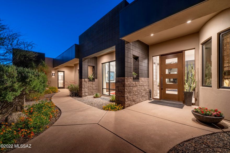 This perfectly executed contemporary home incorporates a masterful blend of textures, elegant finishes and stylish details. Located in the highly sought after gated community of Pima Canyon Estates and behind the secondary gates of The Reserve at Pima Canyon, the arrival sequence of this striking retreat creates a visual juxtaposition that embraces both the native desert landscape, while contrasting the timeless architectural design. The delineation point between contemporary design and the natural desert landscape emphasizes the beauty of nature against the shape and form of the stuccoed and clad structure. Upon entry, the view extends into the great room giving the space a sense of lofty expansiveness, while allowing natural light to sweep in and the eye to move past the walls of vertical glass out onto the rear veranda, with unobstructed Catalina Mountain views beyond.

The kitchen features custom millwork, with contrasting wood tones and drawers dressed in stainless steel hardware, set against an oversized center island, serving as a focal point in this kitchen of range and proportion. Travertine floors line the interior, threading the living spaces together, providing continuity to the overall design. The floor plan, while open, features a split bedroom makeup, with the owner's suite privately sequestered on the Northeast end of the residence, with the secondary junior suite situated on the West end. Walk through a private desert breezeway to a detached guest ensuite and home gym that is perfectly utilized as a tranquil retreat, or cozy guest living quarters. 

Enveloping the residence are numerous outdoor living spaces that seamlessly connect and integrate within the natural desert landscape, each having been thoughtfully positioned for entertaining, while overlooking the built-in spa and outdoor kitchen, both elegantly and effortlessly nestled within space. 

Located within minutes to La Encantada shopping center, fine and casual dining, and La Paloma Country Club featuring world class tennis facilities, fitness, a 27 hole Jack Nicklaus designed golf course managed by Troon, and a resort pool complex.