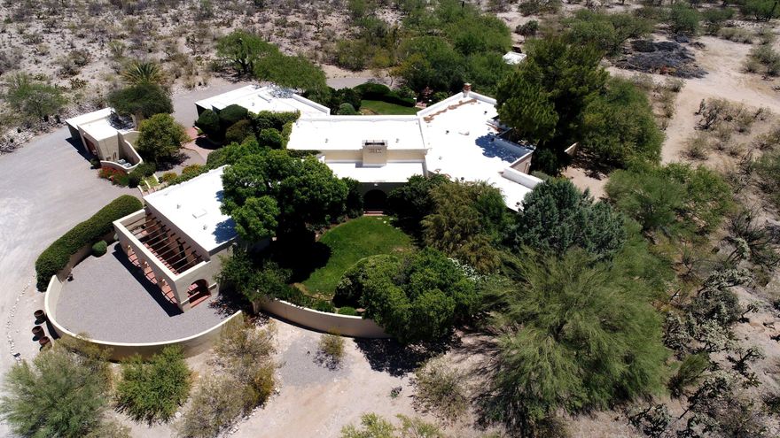 Exquisite estate on 18+ acres south of Canyon Ranch and close to Sabino Canyon offers exceptional privacy, personality & incredible architectural details. Stunning main house is surrounded by courtyards, patios & gardens...all w/ lovely views. Inside you'll find 4 wings, gorgeous high beamed ceilings, spectacular arched windows, 5-FPs & hand carved doors. Captivating kitchen opens to formal dining room & splendid greatroom...all wonderful for entertaining. Master Wing has separate his/her baths, closets, private garden & pond. Extraordinary Gst Hse has wonderful views, FP, courtyard & lush lawn. A Nature Conservancy easement protects the land, flora & fauna. Old world charm abounds and priced below appraised value. The discriminating buyer will be pleased to invest in such a treasure!