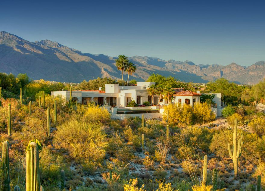 Stunning, one of a kind Spanish Colonial style home high on a hill in the Catalina Foothills Estates with sweeping city and Catalina Mountain views, unsurpassed quality and no detail left unconsidered.  A long and winding driveway leads to grand, wrought iron entry gate, then up the hill to the 5,022 sq. ft., all masonry stucco masterpiece.  Massive historic Sabino wood front door from Holler & Saunders opens to soaring foyer with high, massive cross beams, handmade forged steel windows and doors, leading into great room with inspiration from the Arizona Inn, white-washed beamed ceilings, Venetian plaster walls, glorious city views, clerestory windows, a symphony of doors including hand carved doors by Walt Lewis, antique light fixtures from Mexico and cherry hardwood floors. Kitchen offers old milk finished cabinets, historic Mexican chandelier, designer appliances and hand painted ceiling.  One-of-a kind master offers two master bedrooms, custom dual walk-in European style closets, travertine floors, office and views from every window.  Separate guest quarters, glorious professionally landscaped yards by John Stropko, negative edge lap pool, gazebo with fireplace for outdoor dining, 3 car garage, astounding design and style in all features make this a must see property for those wanting authentic Tucson character and quality.