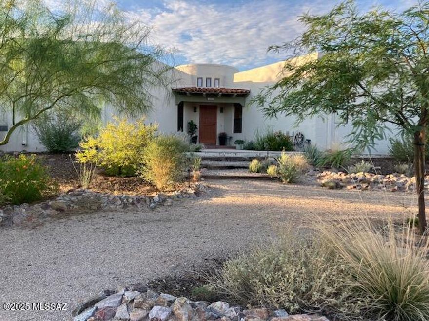 Welcome to this beautifully updated desert retreat, perfectly perched on a lush homesite with mountain views! Offering over 2,000 sq.ft. of thoughtfully designed living space, this home effortlessly blends comfort and warm Santa Fe style. Step through the charming, rounded foyer into a bright and welcoming family room, complete with a cozy beehive fireplace. The renovated kitchen is a true showstopper--featuring quartz countertops, new cabinetry with stylish hardware, updated appliances, a breakfast bar, and a coffered ceiling with skylight that fills the space with natural light. Four additional skylights enhance the lighting throughout the home.  Abundant storage includes a floor to ceiling wall of cabinetry in the living room. The spacious primary bedroom boasts an en suite bathroom, plus TWO walk-in closets for added privacy, relaxation and convenience. Professionally landscaped front yard featuring native plants and rainwater harvesting.  Out back, you'll find a serene brick patio with built-in gas BBQ! Backing a natural wash, the expansive desert and wildlife viewing is unmatched! Ideally located near shopping, dining, schools, and recreation--this home truly has it all!