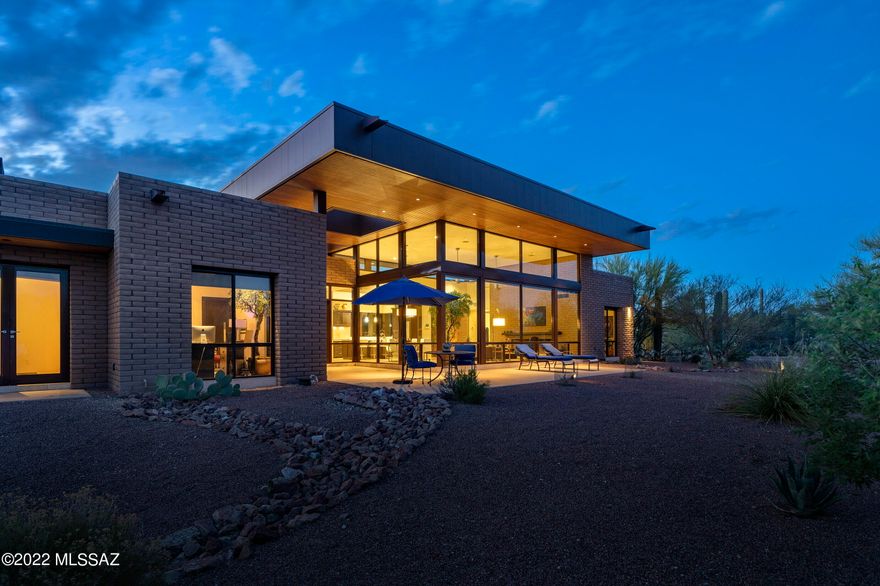 Built in 2013, this Robinette desert contemporary is the ultimate lock & leave AZ residence. Ideal property for pilots, equestrians, or anyone seeking a peaceful, sanctuary-style setting w/ extraordinary views & abundant wildlife. This privately gated home is located on an 8.42-acre saguaro-studded mountain view lot w/ unmatched privacy in the La Cholla Airpark- a private residential airpark in the foothills of the Tortolitas. A long, exposed aggregate driveway surrounded by natural desert leads to this striking custom home built w/ concrete block, walls of glass, metal & wood & offers a contemporary design that effortlessly brings the outside indoors. Have all of the luxuries & amenities expected without the maintenance & upkeep of a large home. Efficient 2800 SF,  2-bedroom/2-ba CONT... home with an open, split bedroom floor plan & oversized 3-car garage with a mini-split for temperature control.  Great room with soaring ceilings, an impressive concrete block gas fireplace & walls of windows that channel natural light & capture glorious views of the Catalina Mountains & the surrounding natural desert. Magnificent kitchen with a center island & breakfast bar.  Custom cabinets, Silestone countertops, stainless steel appliances including gas cooktop, & walk-in pantry. The corner window at the kitchen sink captures scenes of the desert outside. The formal dining area in the great room is adjacent to the kitchen. A sizable master suite with a see-through fireplace has a bonus area that can be used for an office or any needed use.  Oversized master bathroom with custom dual sink vanity, shower with one of a kind tub with lights, music, aromatherapy, jets & bubbles.  Spacious shower with floor to ceiling tile with glass door that leads to private, walled yard space with an outdoor shower, artificial turf & stairs to the rooftop deck. Enjoy sunsets that paint the sky with vibrant colors and starry nights from the rooftop deck. Huge master closet that would typically be found in a much larger home with custom built-ins.  Adjacent to the master bedroom is a bonus room currently used as a dedicated massage room.  On the other side of the home is a private guest bedroom & a large full bath with tile surround shower . The laundry room with custom cabinets & storage leads to an oversized 3-car garage with a sink,  temperature control, epoxy floors & allows for multiple uses or storage opportunities. The current owner is using overflow space for an exercise area. Other features include a tankless water heater & a propane tank installed to fire gas appliances & fireplaces.  Superb northwest Tucson location convenient to the Stone Canyon Golf Club- a world-class country club w/ tennis, pickle-ball, fitness & social events in addition to golf.  
La Cholla Airpark Information:
At La Cholla Airpark, residents live with their planes, horses, and abundant wildlife around a 4500-foot paved and lighted runway. The Airpark is 20 miles northwest of Tucson, AZ, and set on 1.5 sections, or about 1000 acres. All lots are a minimum of 7 acres.
La Cholla Airpark is a private residential airpark. The runway is for the use of residents and their guests. Transient aircraft are welcome on prior permission only basis. 
Our large lots afford us a rural lifestyle, including horses, with shopping and schools nearby. Wildlife is abundant, with frequent sightings of Deer, Javelina, and Harris Hawks to name a few.
Nearby Stone Canyon Club Information:
Stone Canyon is a hidden gem nestled against the picturesque Tortolita Mountains in the town of Oro Valley, just northwest of Tucson, Arizona. This private golf community boasts over 1,400 acres of breathtaking land and is highlighted by a Jay Morrish designed world-class golf course. Stone Canyon is the only golf course in the greater Tucson area ever to be ranked in the top 100 golf courses in America according to Golf Digest. Accompanied by a luxurious Health & Fitness facility and a modern restaurant, Stone Canyon leaves no stone unturned in providing you with all the comforts one could desire. Enjoy our many golf, social, and fitness events hosted consistently throughout the year.
 
 In early 2016, our newly designed Clubhouse was opened. The 25,000 SF complex features a men's and women's locker room, golf shop, dining room, indoor bar, outdoor bar with a fire pit, along with ample outdoor covered seating. Situated directly behind the 18th green, the Clubhouse provides 270 degrees of amazing views. Whether it's looking back up the 18th fairway or taking in the majestic Santa Catalina Mountains at sunset, the Stone Canyon Clubhouse is the perfect setting for post-round cocktails or dinner with friends and family.