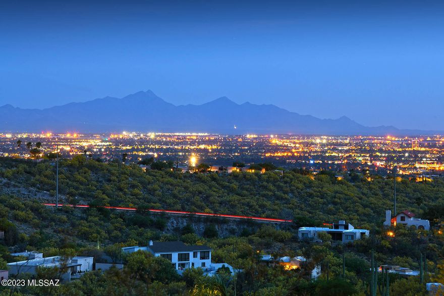 Views! Views! Views! Striking panoramic unobstructed views of 3 mountain ranges & colorful sunrise/sunsets, surround this SW contemporary home. Located in the heart of Cimarron Foothills Estates you will find this gem. The paver driveway & lush desert plantings at front entry begin your journey inside. There are views from EVERY WINDOW! Formal DR & LR have spectacular city lights & Santa Rita Mountain range vistas. Kitchen is a great room concept & has wonderful bright blue tile counters, saguaro rib cabinets & SS appliances Enjoy the cozy wood burning FP in the family room. Primary BR w/slider to the SW patio is where you will enjoy your private spa & screened in porch while taking in all of views. Guest BR & bath showcase the Catalina & Rincon Mtn backdrop. One acre land & owned solar!