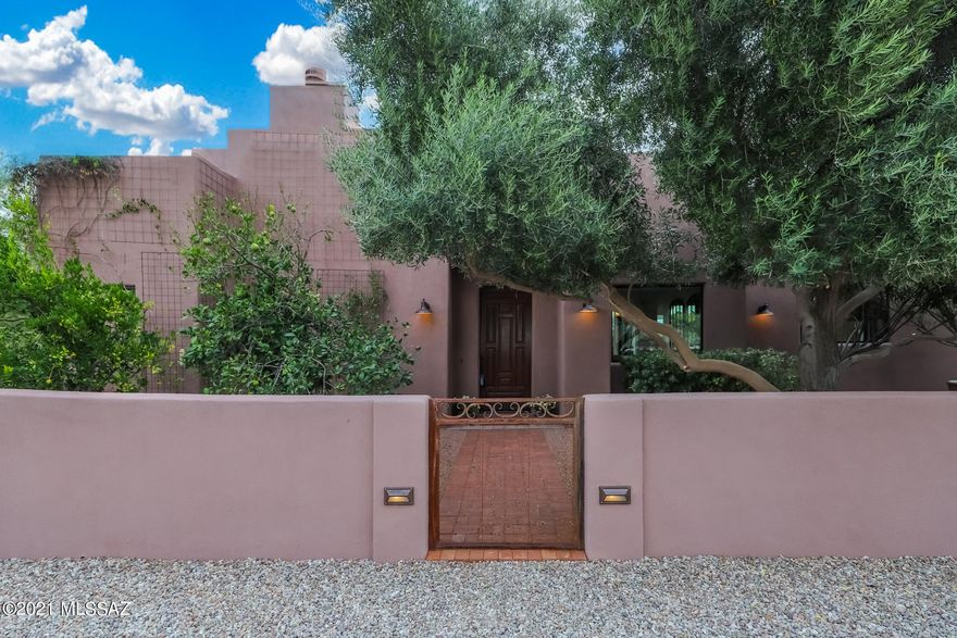 Elegant, yet charming and comfortable home is nestled in the desert on a private, but central acre-plus lot. Gorgeous views of the mountains and surrounding desert from every room. This 2011 home mixes traditional Tucson style with modern touches. Features include an entry courtyard with fountain, high ceilings, colored concrete floors, alder cabinetry and doors, beamed ceilings, and Spanish style and custom concrete tilework. Large kitchen with extensive cabinetry, pantry, induction cooktop, dual ovens, and oversized stainless steel island. Back yard is perfect for playing or entertaining with more of those gorgeous views and a tranquil pebble-tec pool  that blends with the desert in a pond like setting. Three car garage with extra storage and work space is plumbed to allow for conversion of one bay to a 4th bedroom and bath.  Additional comforts include: dual zone HVAC, supplemental solar powered water heating, water softening and filtration systems, rain water collection, zoned irrigation for the landscaping, and in-ground cleaning system for the pool.  No details were overlooked. This home was designed for both comfort and beauty and for both raising families and retiring and