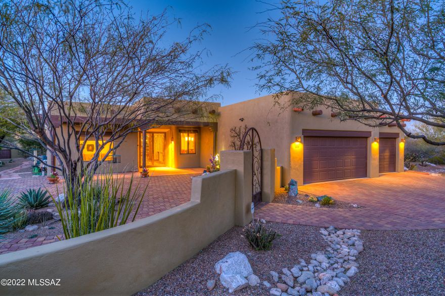 The 360 roof top patio with AMAZING views of the canyon & mountains is just the beginning in this exquisite 3 bedroom 2.5 bath split floorplan with an oversized garage & fully fenced yard (front, rear & side patios with custom gates in which to enjoy bird & wildlife, garden (rain catchment system) or entertain friends).   This home is a fusion of great architecture & nature with two water features, roll down blinds and more.   Classic sophistication abounds in the open concept floorplan—the great room has custom beams, a kiva fireplace & opens to banquette dining & custom extended cook's kitchen (Viking Range 6 burner gas range, convection oven, granite countertops with hand-chiseled edge, venetian plaster custom hood, custom backsplash, walk-in pantry).  See upgrades list for more detai Lovely dining room with custom walls by Sally Richards. Den with doors and beams that looks out onto front patio.  Two guest bedrooms flank a guest bath.  Primary en suite is modern tranquility with old world charm.  Wired for solar. Anderson Windows. Tesla charging station.