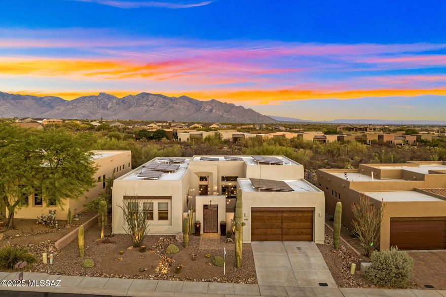 Tucked away in the gated community The Preserve at Dove Mountain, 12320 N Sunrise Shadow Drive offers gracious desert living in an energy efficient solar powered home. Sitting on an elevated Eastern facing lot with designated open space behind, the property offers unobstructed Catalina Mountain views. Built by a local custom builder Insight Homes, the Santa Fe style architecture is blended with modern elements creating a clean, yet comfortable setting. Substantial in size, the front courtyard is finished with pavers, functioning as another room of the home. Inside, a sense of airiness is felt from 12-foot-high ceilings, oversized windows and generous spaces. The 2,417 sq ft layout includes 3 bedrooms and 3 full baths, with an extension on the front of the home, effectively creating dual primary suites. Large format tile spans the great room and chef's kitchen, which includes granite counters and GE Monogram appliances. A separate bar area includes a beverage refrigerator, providing effortless flow for entertaining.

Improvements made over the last several years are abundant, high end, and include: a fully owned TESLA solar system with 3 power walls, new 80 gallon electric hot water heater, 2 new HVAC units, a whole house humidification system, roof recoating with a 10 year product, new exterior paint, new pool equipment, gutters, and a Lutron lighting system. The home also includes a Sonos sound system with speakers throughout.

Completely finished with a pebble tec saltwater pool, in ground spa, and gas fire pit, the backyard is a lovely space to enjoy, yet easy to care for. With a designated nature preserve behind the lot, the desert and mountain views will remain as they are today.

Lifestyle and convenience from this location are dynamic. It's easy to walk, run or cycle from your front door with neighborhood sidewalks, a trail system and multi-use paved path all immediately accessible. Within Dove Mountain, there are 3 golf clubs, the Tortolita Preserve with 10 miles of singletrack, and the Wild Burro trailhead with peaceful and varied hiking trails. Within 2 miles, there are plazas with grocery, dining, pharmacy, urgent care, veterinary, banking, and other services. From this location, interstate access is quick and easy, making travel to Downtown Tucson, the Tucson Airport, or the Phoenix metro area simple.