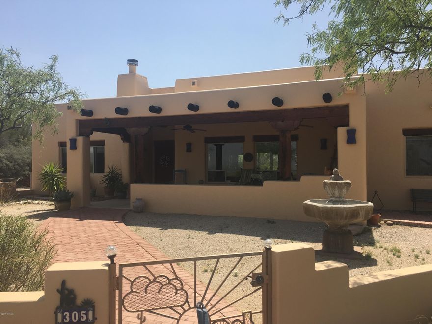 Lovely Santa Fe home featuring a welcoming entry & expansive great room w/ fireplace & large north facing picture windows to showcase the Catalina Mountain views, soaring ceilings w/ gorgeous wood beams, spacious kitchen & breakfast nook, formal dining room w/ french doors. Entertainers dream backyard with a negative edge pool, water feature, built-in BBQ & several outdoor living spaces.Over-sized master bedroom features another large picture window & fireplace.Master Bathroom en-suite w/ large walk-in closet, separate garden tub & shower.2nd master suite w/ a walk-in closet & private bathroom.Additional 3rd bedroom & full bathroom.3 car garage with plenty of room for an RV or boat.Elevated 4.06 acre lot.Exterior recently painted.
