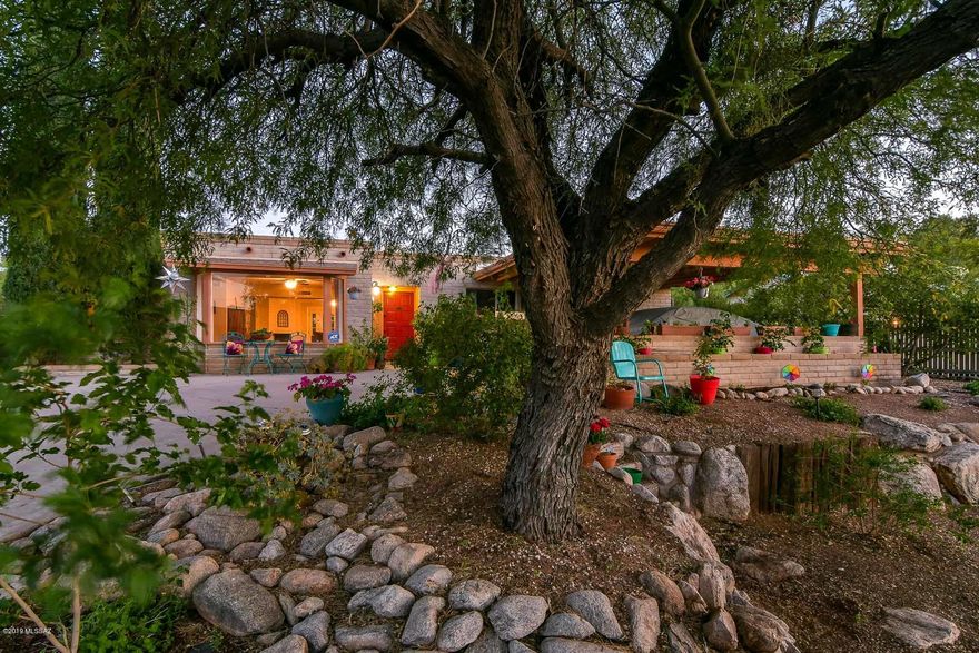 Beautifully landscaped front with lots of vegetation, trees, and decorative landscaping for a fantastic curb appeal. Half circle driveway with big covered parking area and lots of extra parking off street. Solid slump block construction. Wood look ceramic tile throughout. Very open with lots of light and neutral colors. Master has large walk in closet, Huge bay window with fantastic mountain views. Kitchen has all stainless steel appliances included and lots of cabinetry and counter space. Extra large laundry room with additional fridge that also conveys. Living room has a fireplace and french doors leading out to a huge covered patio. Extra storage room out back. Practically a forest with 10 mature trees and lots of additional vegetation all over the property.