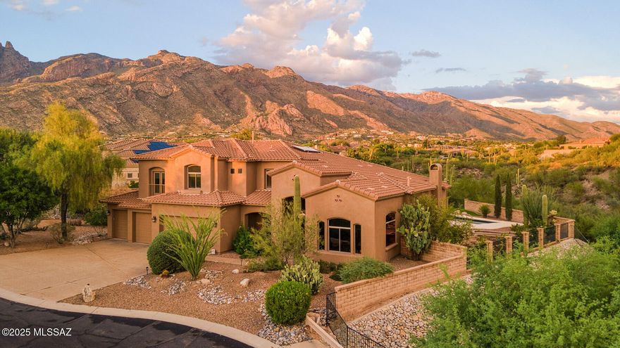 Nestled in the highly coveted Tucson Foothills, this exceptional residence seamlessly blends elegance, comfort, and lifestyle luxury. 

Thoughtfully positioned so that the lot itself is angled toward the mountains, the home was designed to capture sweeping views not only from the backyard but also from within, making the breathtaking desert landscape an integral part of daily living.

The heart of the home is the chef-inspired kitchen, complete with a GE Profile 36-inch stainless steel 5-burner gas cook-top and a GE Profile 30-inch smart double wall oven. This culinary space opens gracefully to the formal dining room, lounge, family room, and an upstairs retreat, creating a natural flow for both intimate gatherings and grand entertaining. Throughout the home, thoughtful details elevate the everyday - indoor and outdoor gas fireplaces, new Hunter Douglas window coverings, new top of the line HVAC systems, new interior paint, and a spacious four-car garage with abundant storage all contribute to an atmosphere of comfort and sophistication.

With five bedrooms and four baths, the home offers space and versatility for family and guests alike. The oversized first-floor primary suite is a private sanctuary, featuring his-and-hers walk-in closets, a spa-like bath, walk-in shower, and dual vanities. Step directly from the master bedroom to the bespoke resort-style lap pool, with sculptural wavy edges and an outdoor entertaining area that invite year-round enjoyment.

Outdoors, evenings are nothing short of magical. Unwind in the raised jacuzzi while the moon rises over the mountains and the city lights shimmer below, or enjoy Tucson's legendary sunsets from the pool's edge. A built-in grill with sink and outdoor fireplace create the perfect setting for alfresco dining and gatherings, while an in-ground trampoline, artificial grass play areas, and raised garden beds offer fun and function for every lifestyle. 

The home's orientation ensures the afternoon sun never overwhelms the backyard, while gentle morning light greets the home in summer and the expansive northeast-tilted windows capture warmth and brightness in winter.

Beyond its private resort setting, the residence offers unmatched convenience. Located just minutes from both the east and west sides of Tucson, it sits within the area's premier school district and is surrounded by top-rated shops, award-winning restaurants, and the natural beauty of the Foothills.

This home is more than a residence - it is an invitation to live Tucson at its finest.